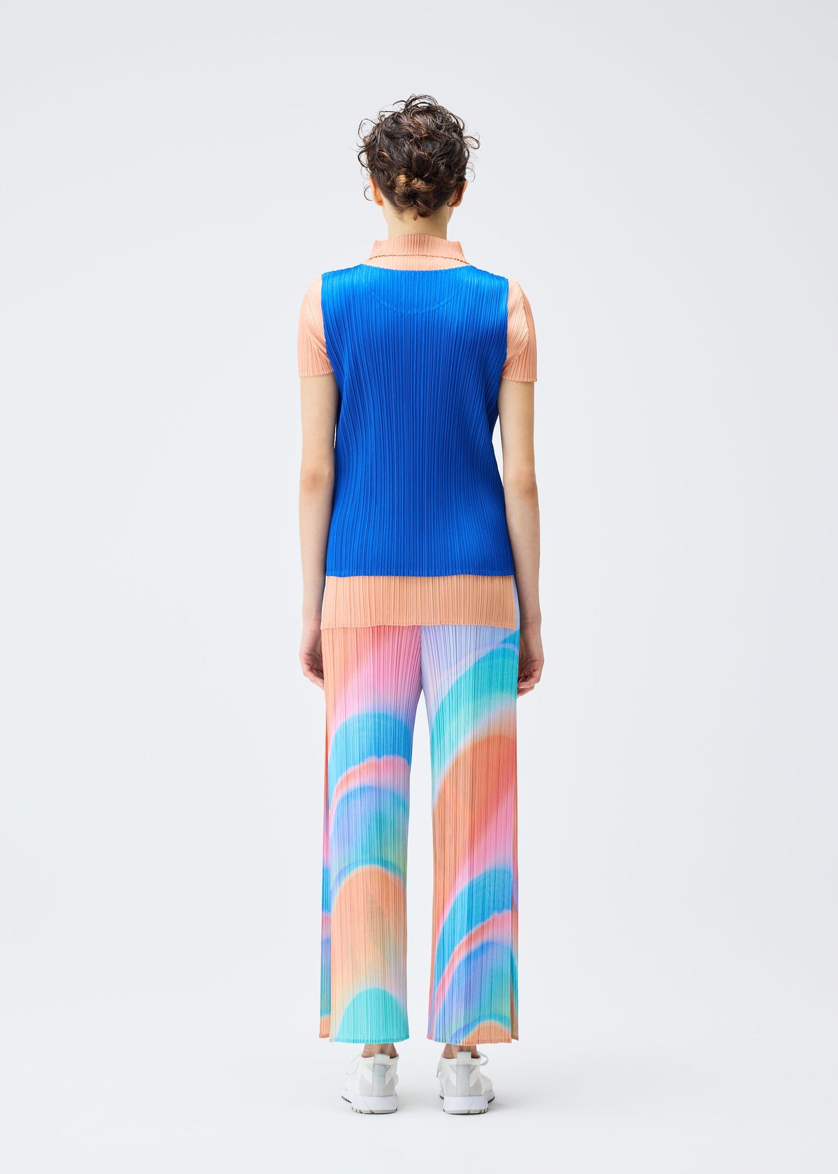 A model wears the PLEATS PLEASE ISSEY MIYAKE GROOVE trousers.