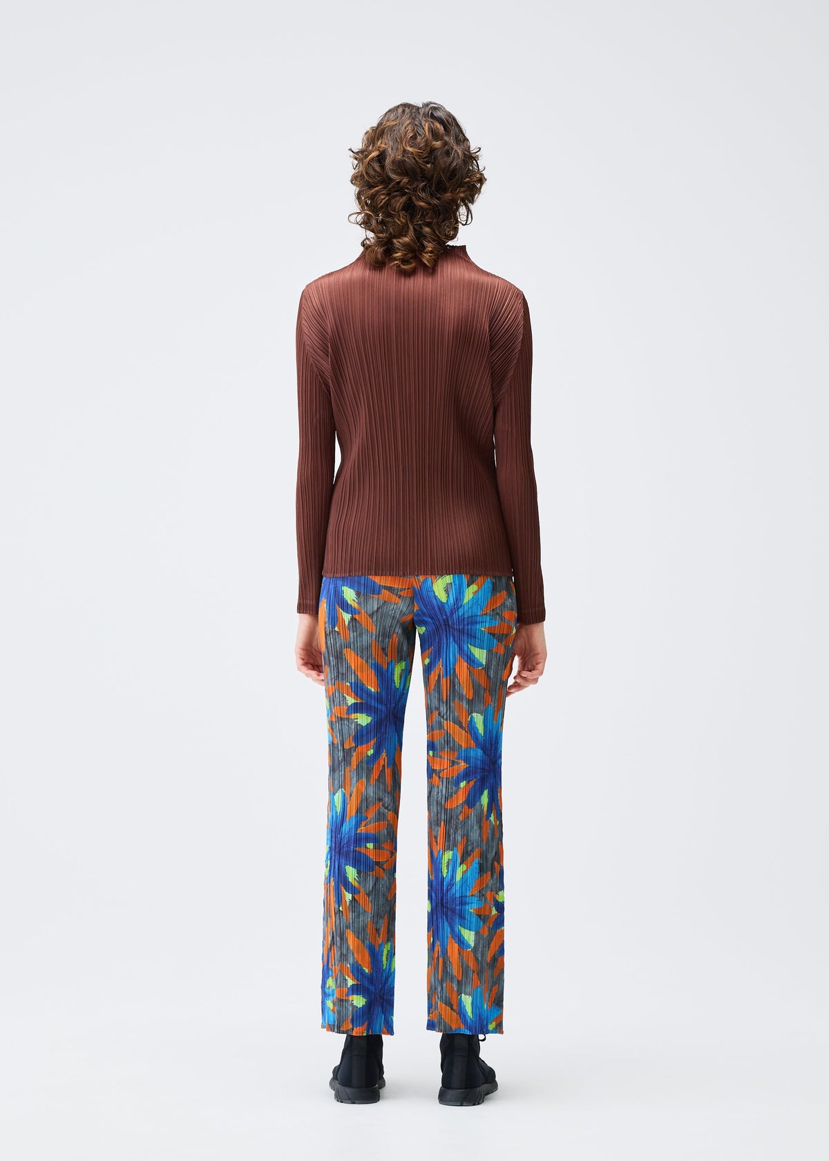 A model wears the PLEATS PLEASE ISSEY MIYAKE CARNIVAL trousers.