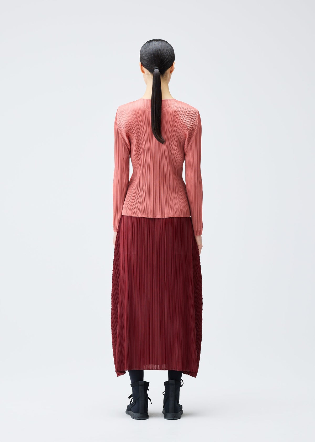 A model wears the PLEATS PLEASE ISSEY MIYAKE MONTHLY COLORS OCTOBER skirt.