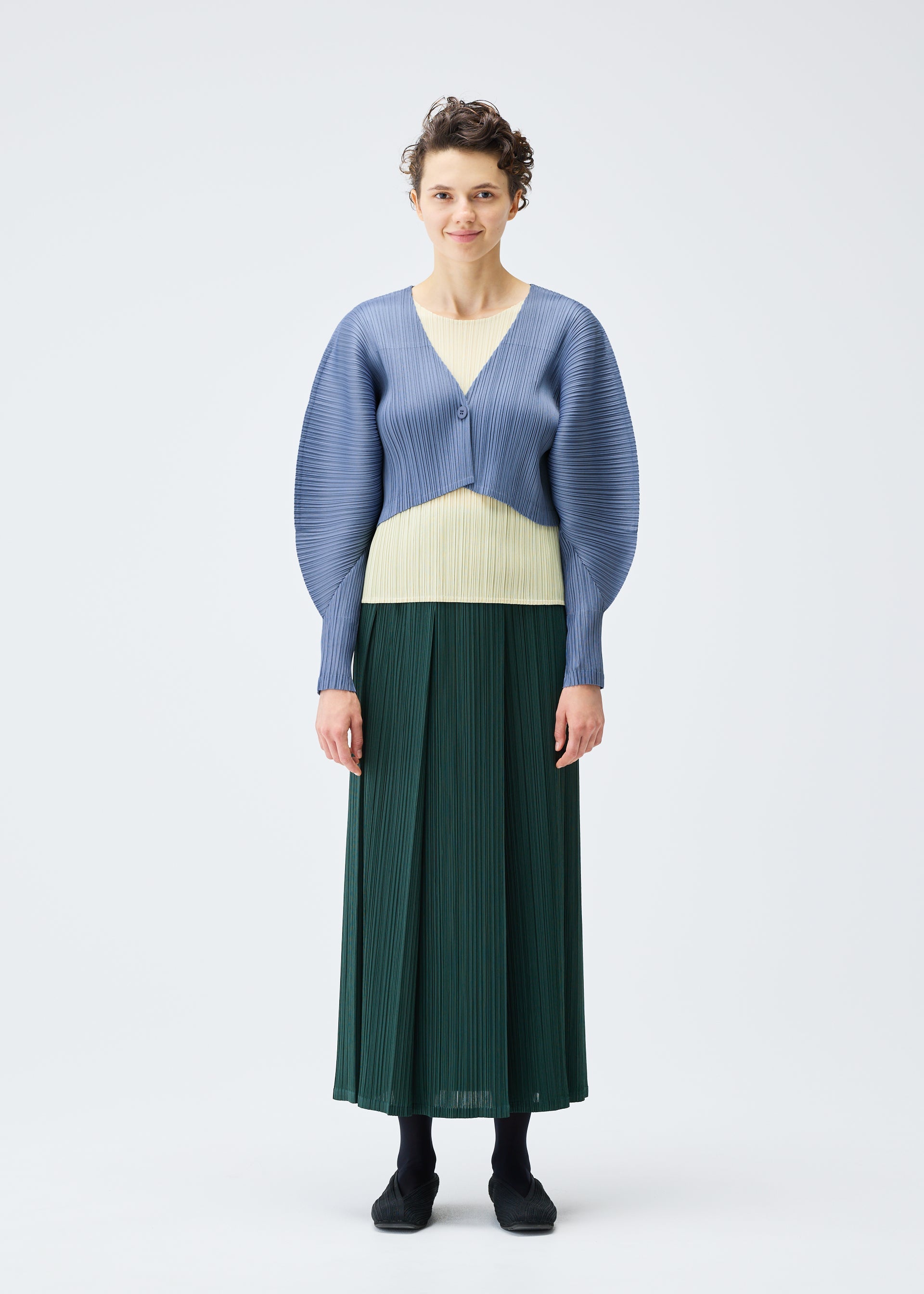 A model wears the PLEATS PLEASE ISSEY MIYAKE MONTHLY COLORS DECEMBER clothing.