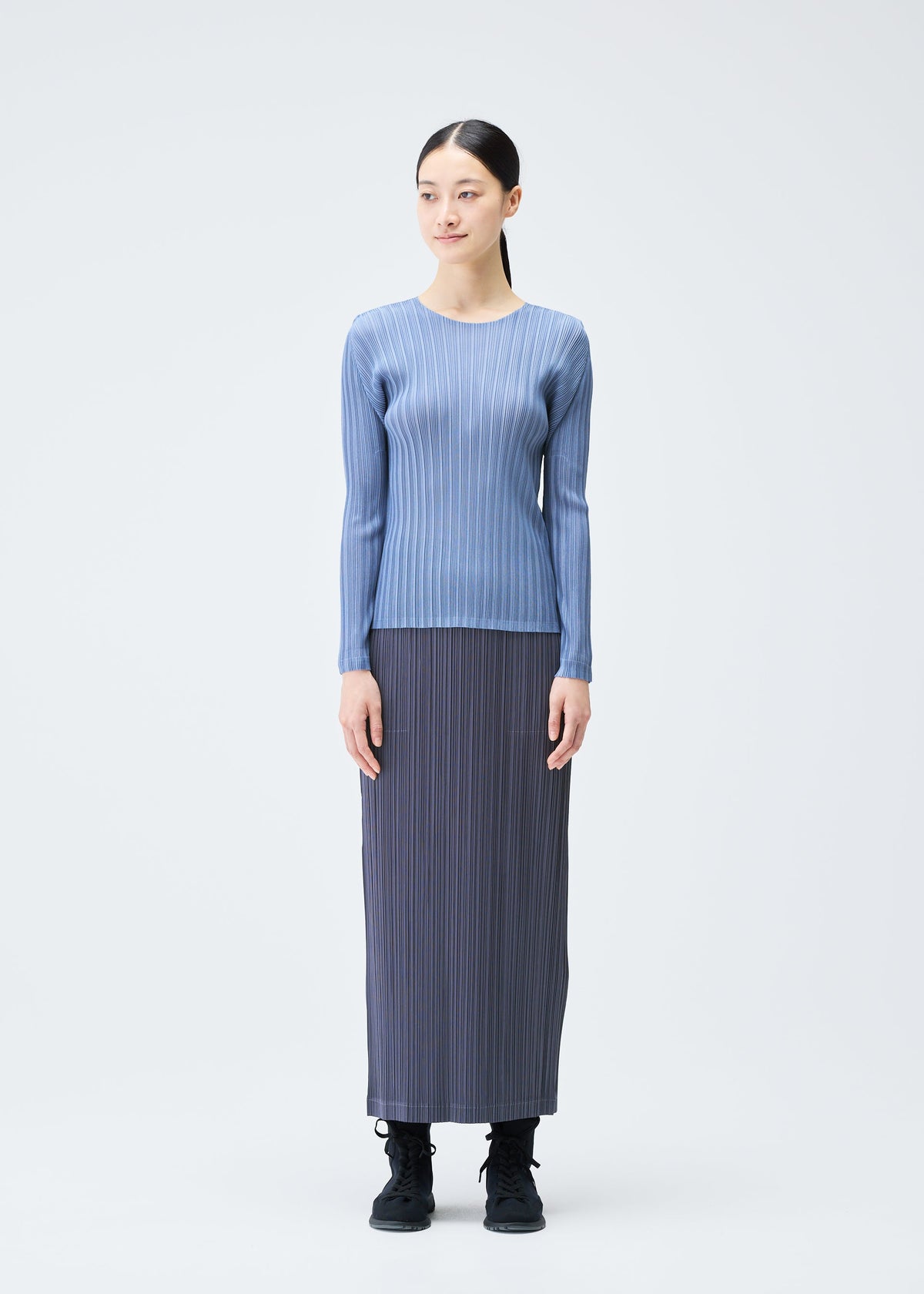A model wears the PLEATS PLEASE ISSEY MIYAKE LOOP BOTTOMS clothing.