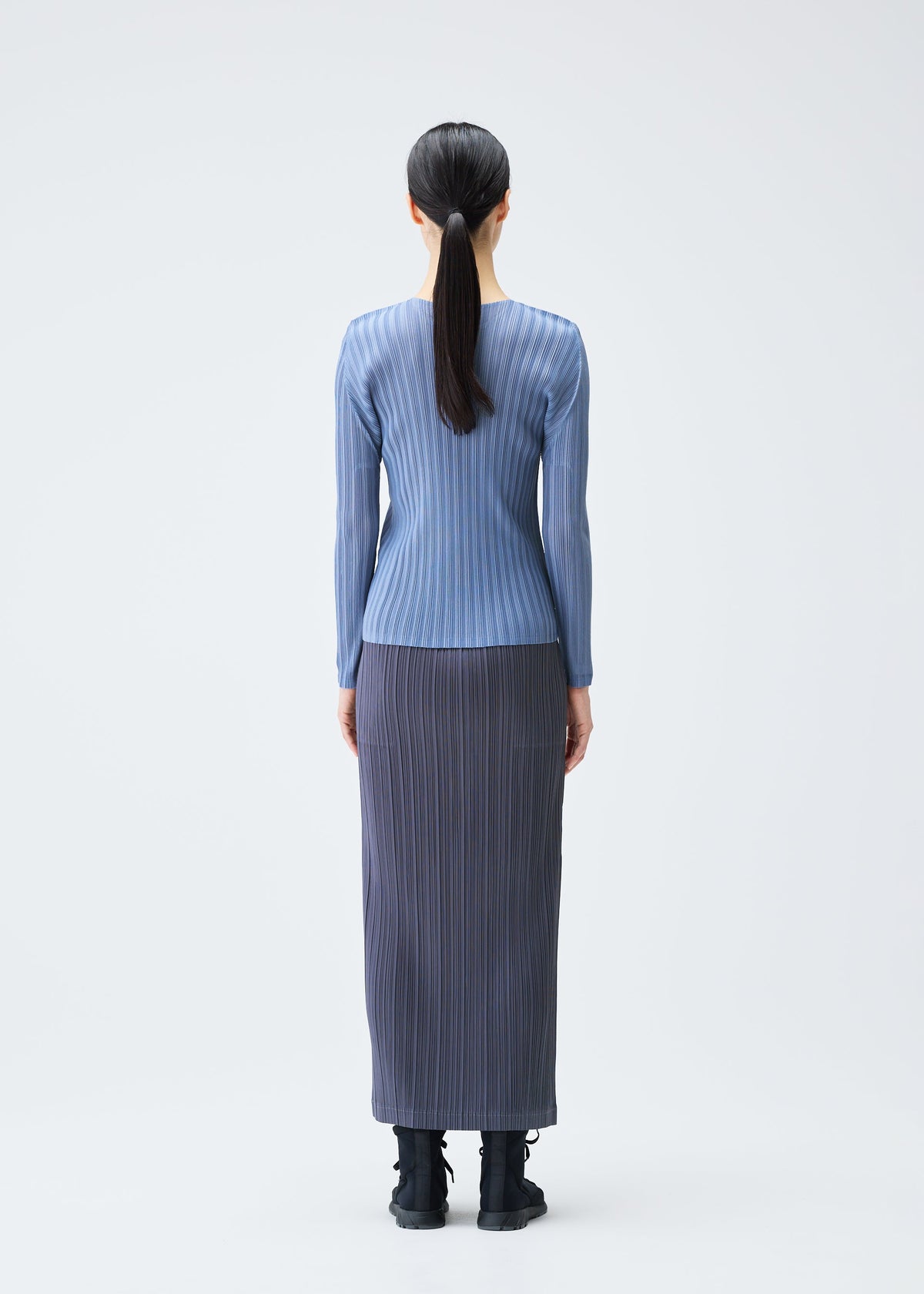 A model wears the PLEATS PLEASE ISSEY MIYAKE LOOP BOTTOMS clothing.