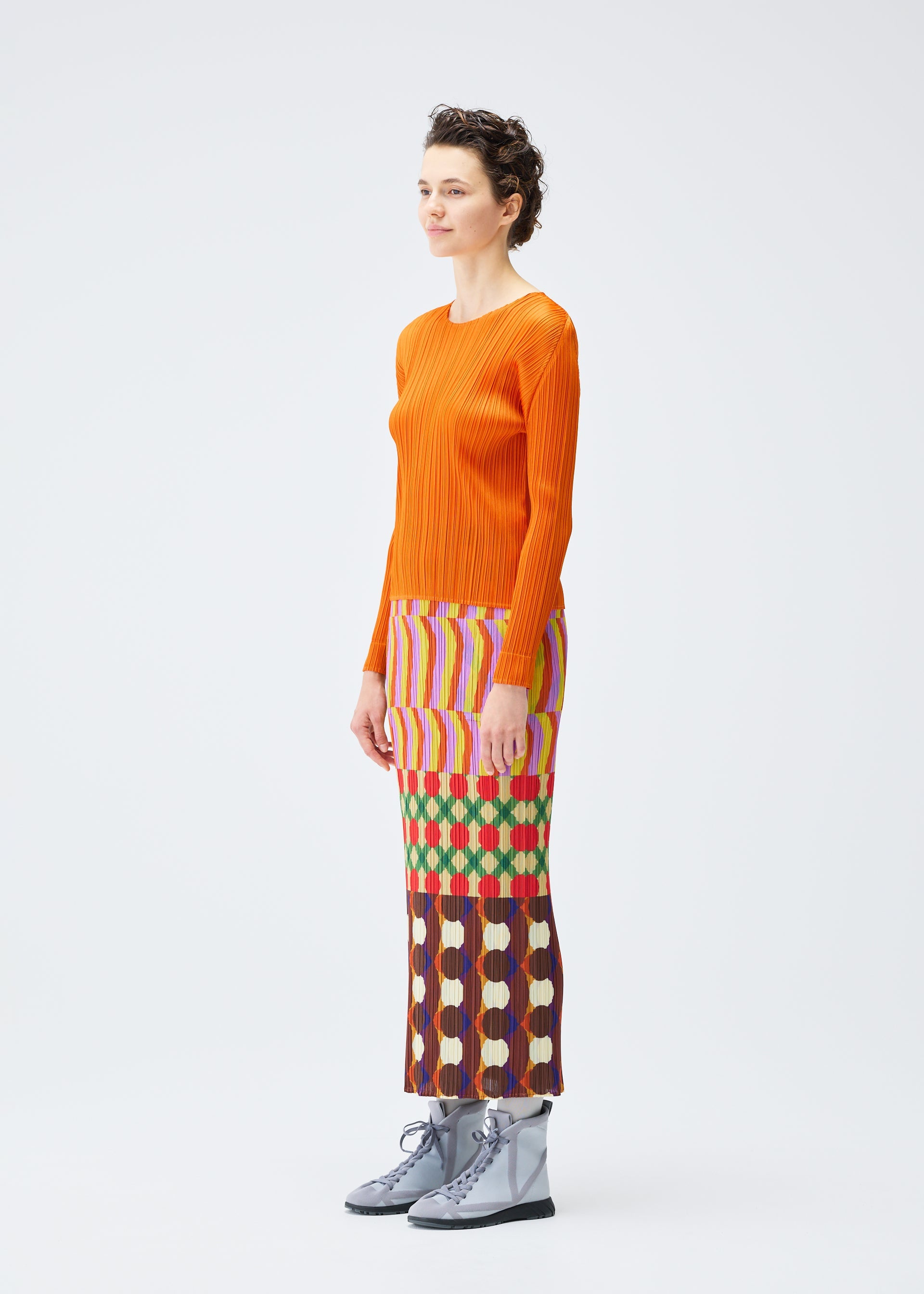 A model wears the PLEATS PLEASE ISSEY MIYAKE HARMONY clothing.
