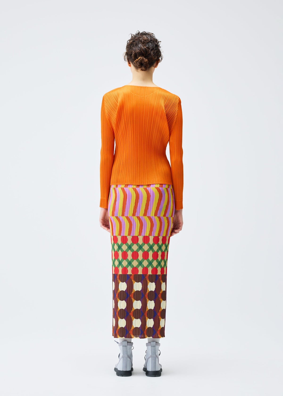 A model wears the PLEATS PLEASE ISSEY MIYAKE HARMONY clothing.