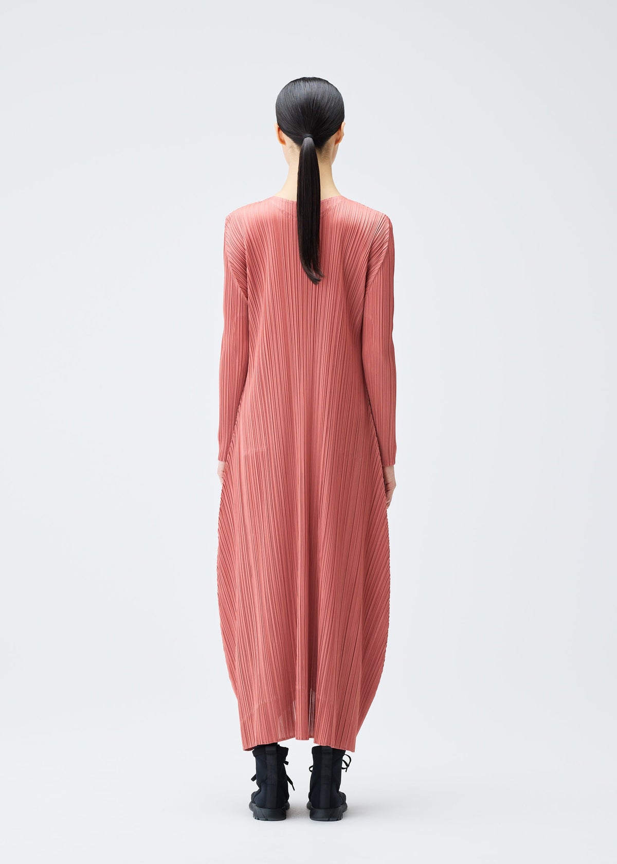 A model wears the PLEATS PLEASE ISSEY MIYAKE MONTHLY COLORS OCTOBER dress.