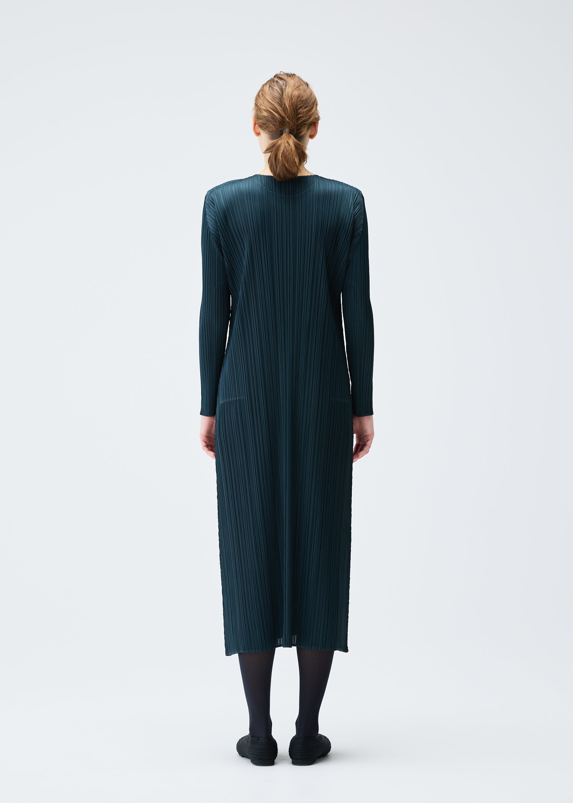 A model wears the PLEATS PLEASE ISSEY MIYAKE MONTHLY COLORS NOVEMBER dress.