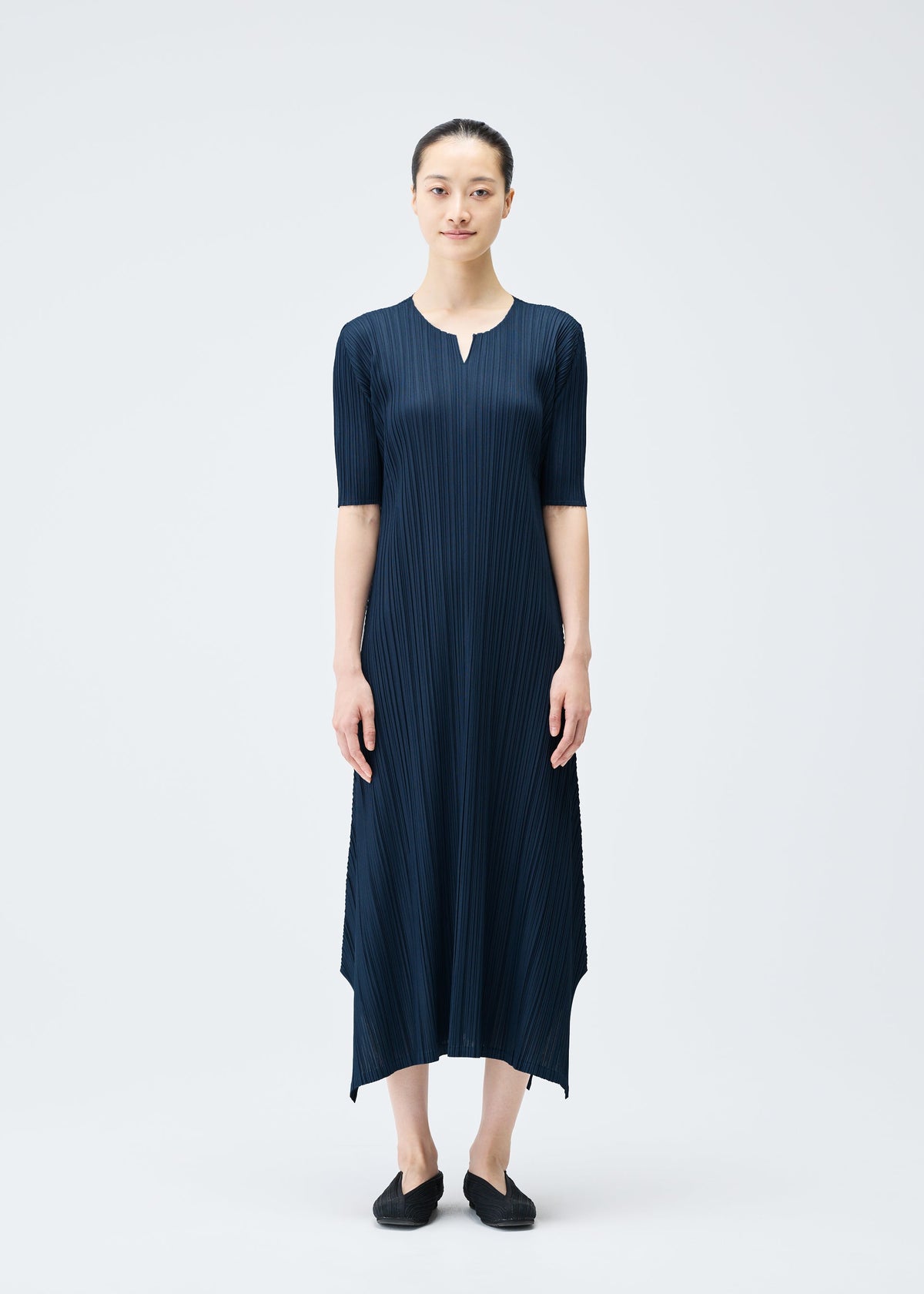 A model wears the PLEATS PLEASE ISSEY MIYAKE MELLOW PLEATS dress.
