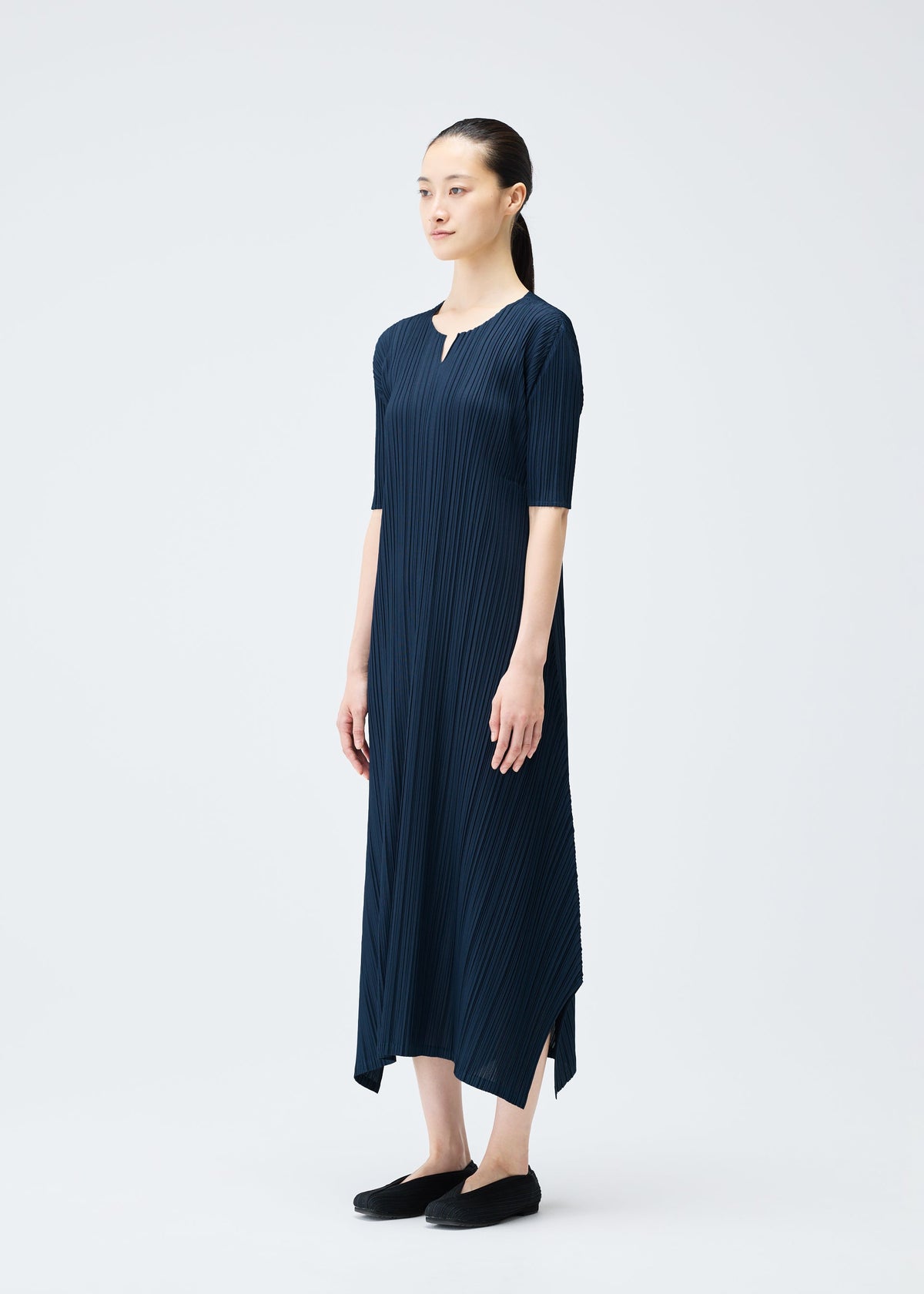 A model wears the PLEATS PLEASE ISSEY MIYAKE MELLOW PLEATS dress.