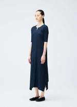 A model wears the PLEATS PLEASE ISSEY MIYAKE MELLOW PLEATS dress.