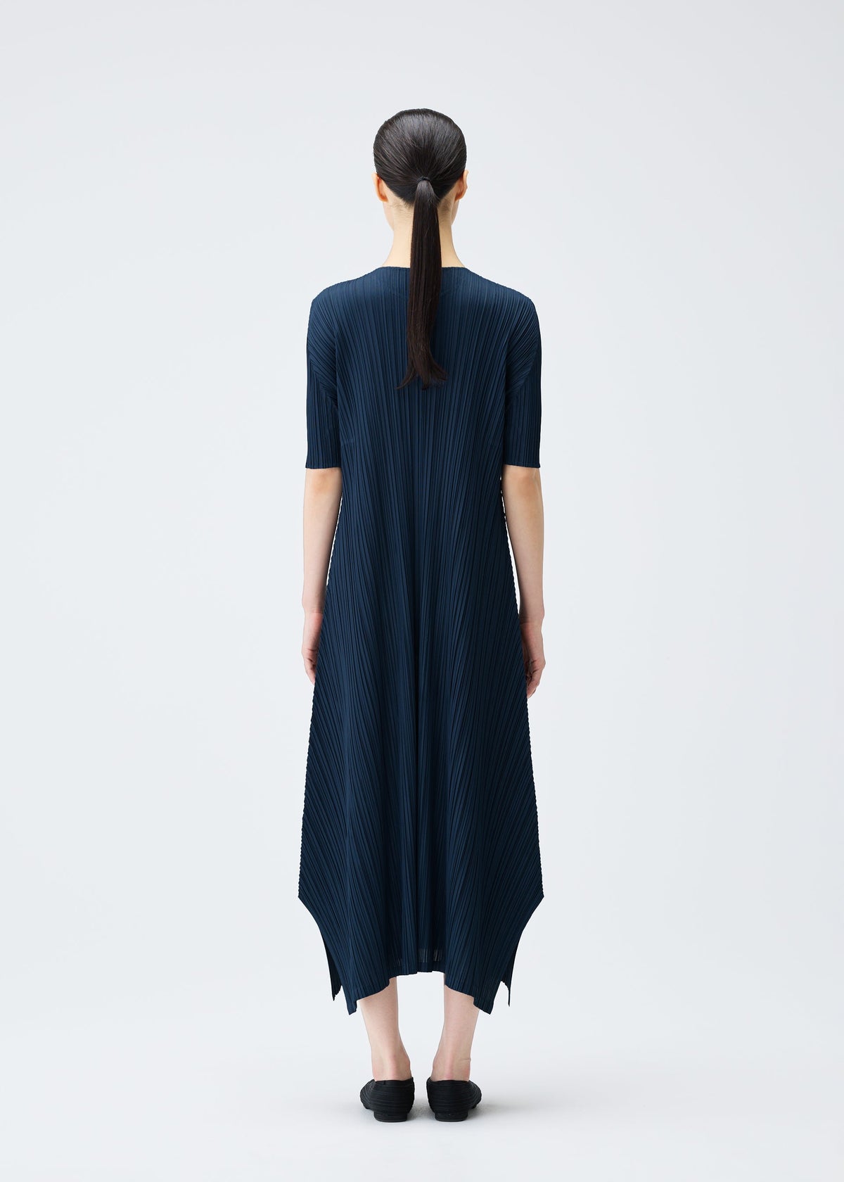 A model wears the PLEATS PLEASE ISSEY MIYAKE MELLOW PLEATS dress.