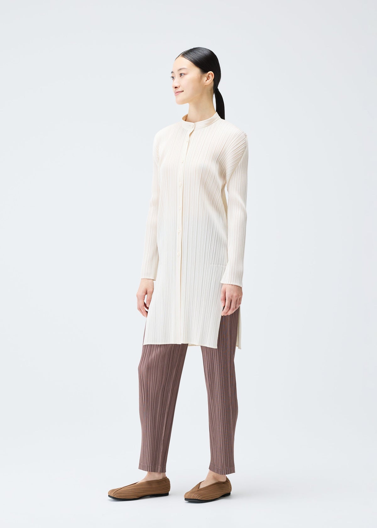 A model wears the PLEATS PLEASE ISSEY MIYAKE PLEATS SHIRT shirt.