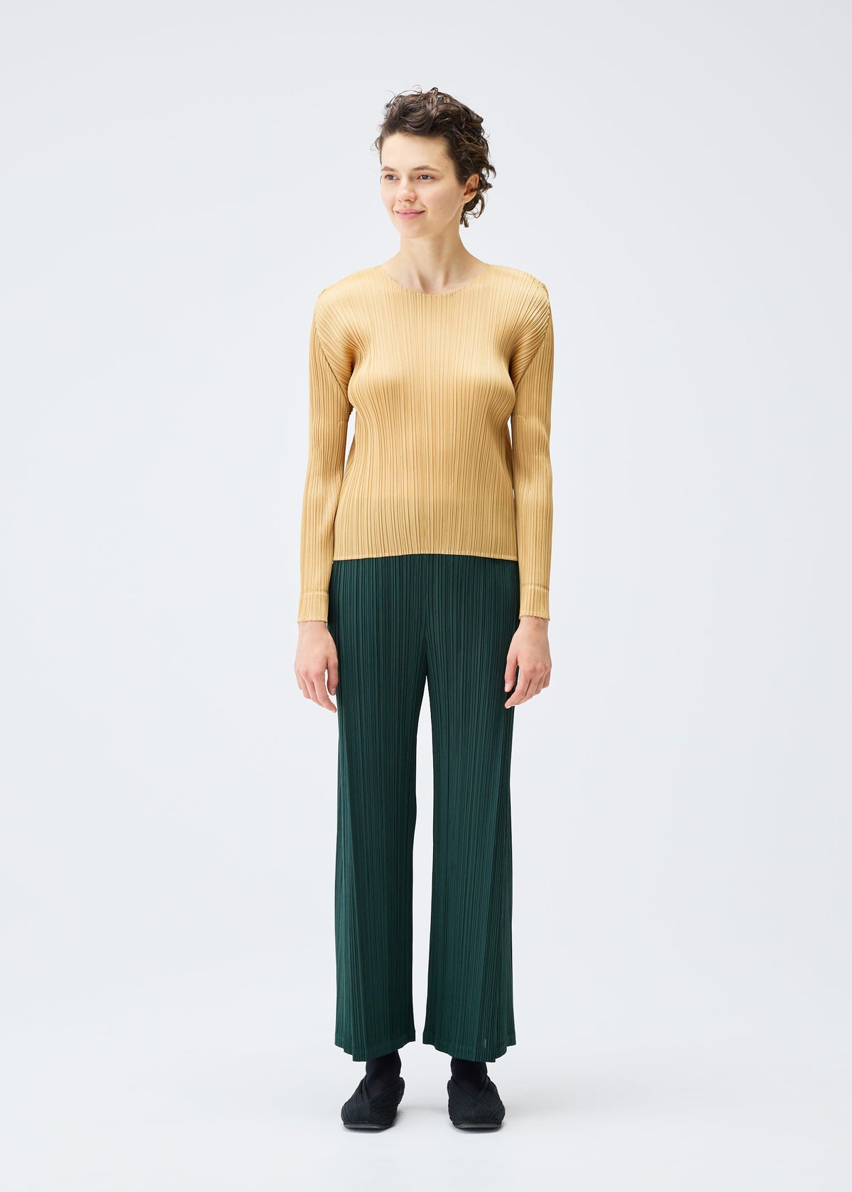 A model wears the PLEATS PLEASE ISSEY MIYAKE MONTHLY COLORS DECEMBER clothing.