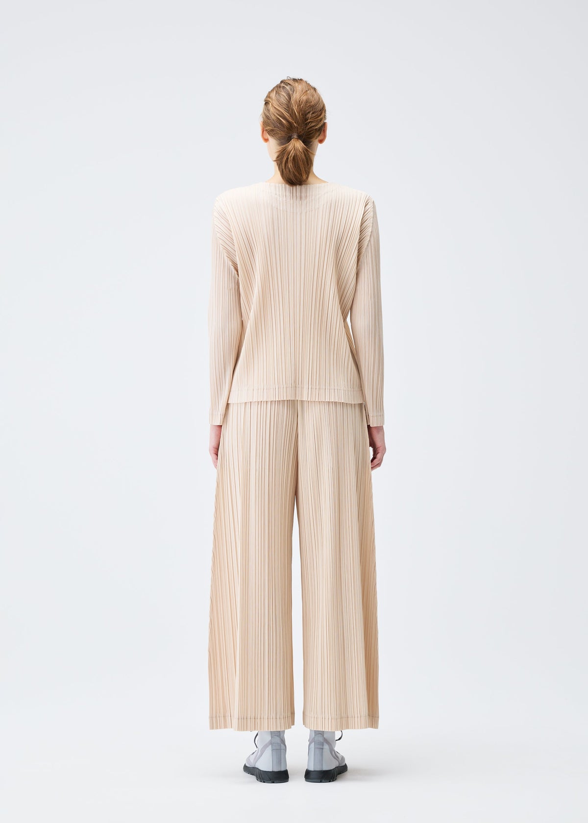 A model wears the PLEATS PLEASE ISSEY MIYAKE WOOL PLEATS top.