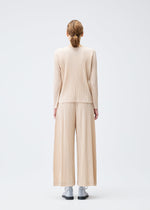 A model wears the PLEATS PLEASE ISSEY MIYAKE WOOL PLEATS top.