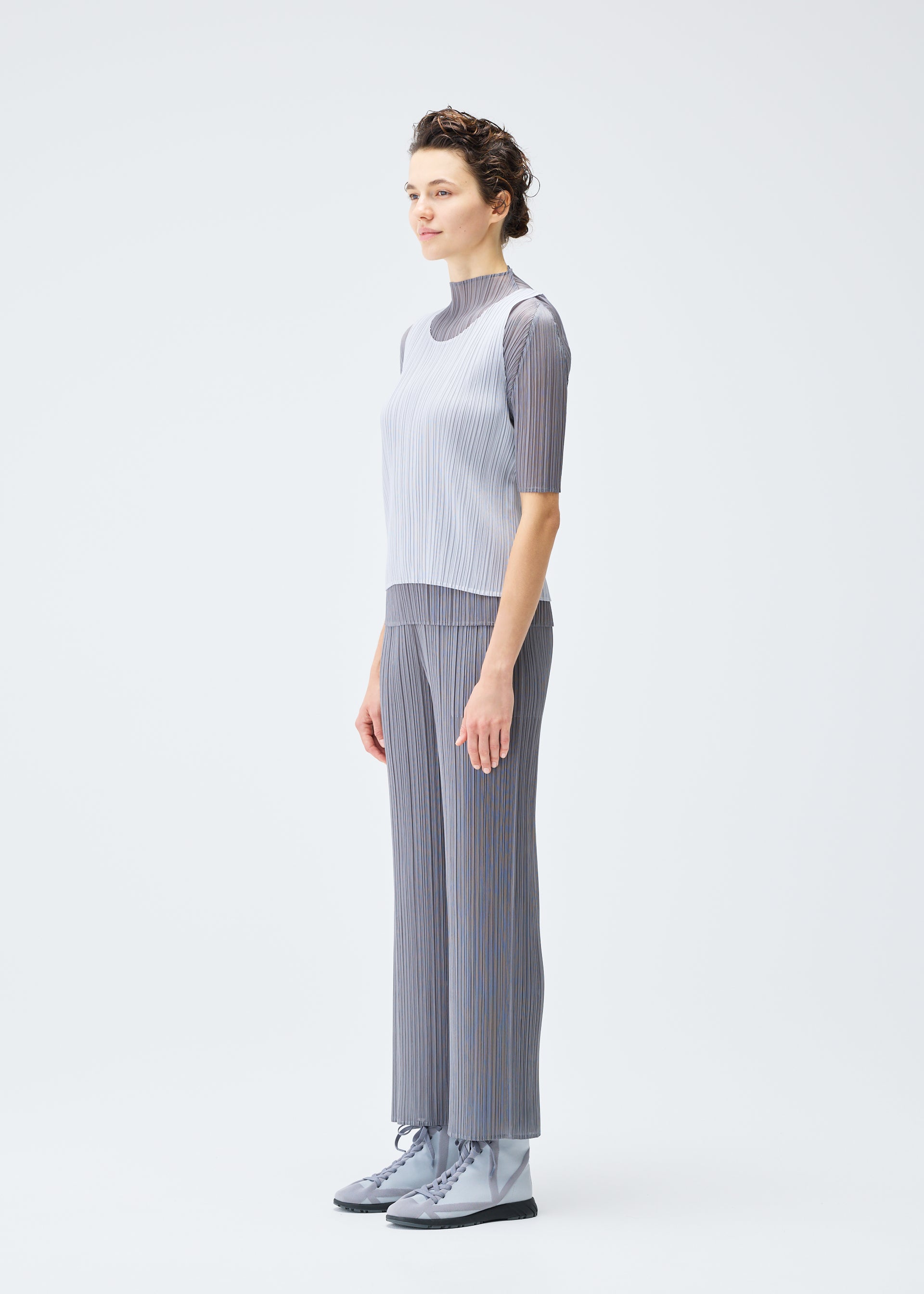 A model wears the PLEATS PLEASE ISSEY MIYAKE LUCID PLEATS top.
