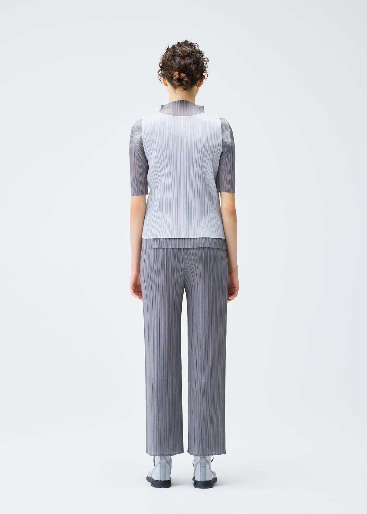 A model wears the PLEATS PLEASE ISSEY MIYAKE LUCID PLEATS top.