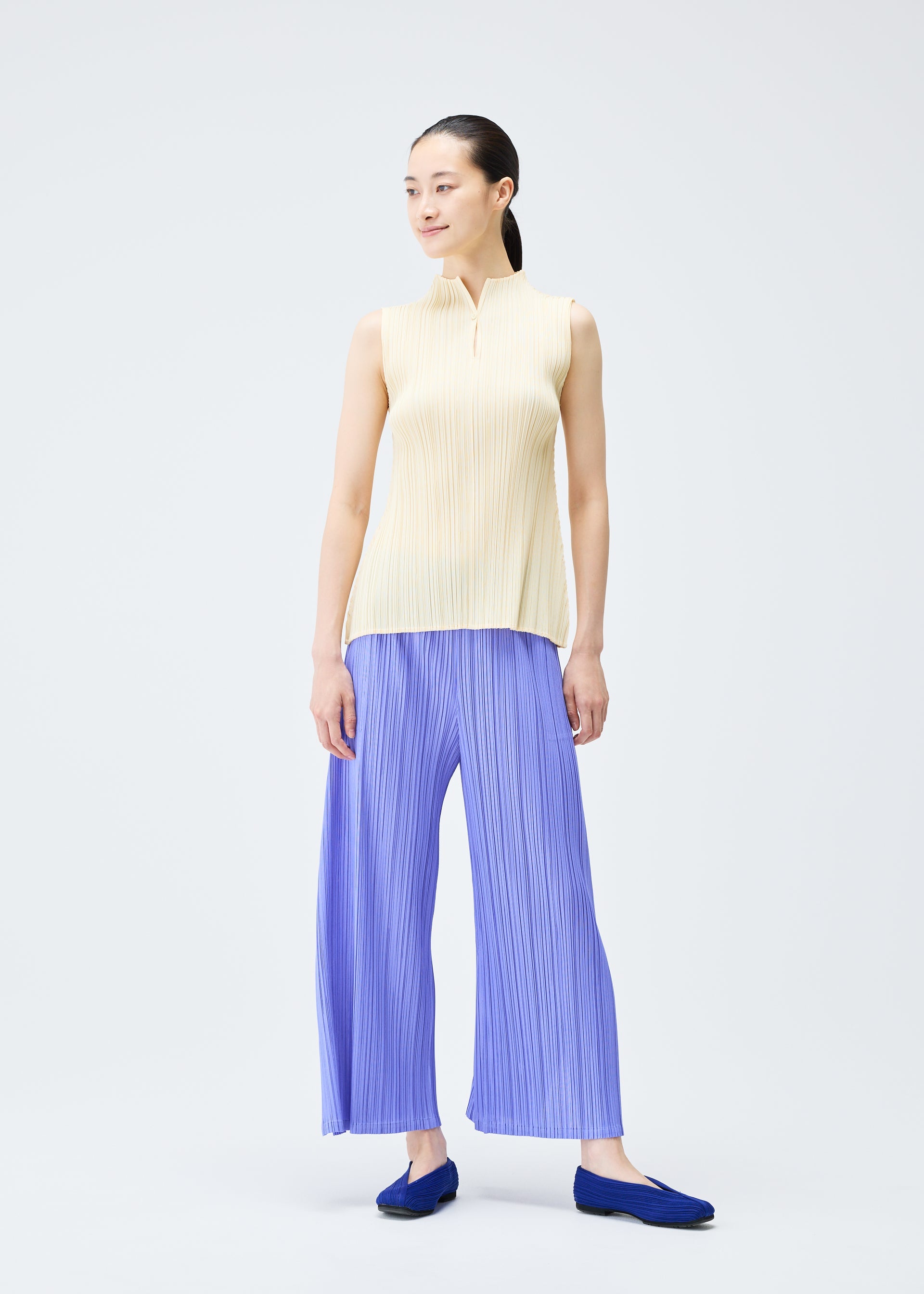 A model wears the PLEATS PLEASE ISSEY MIYAKE MELLOW PLEATS top.