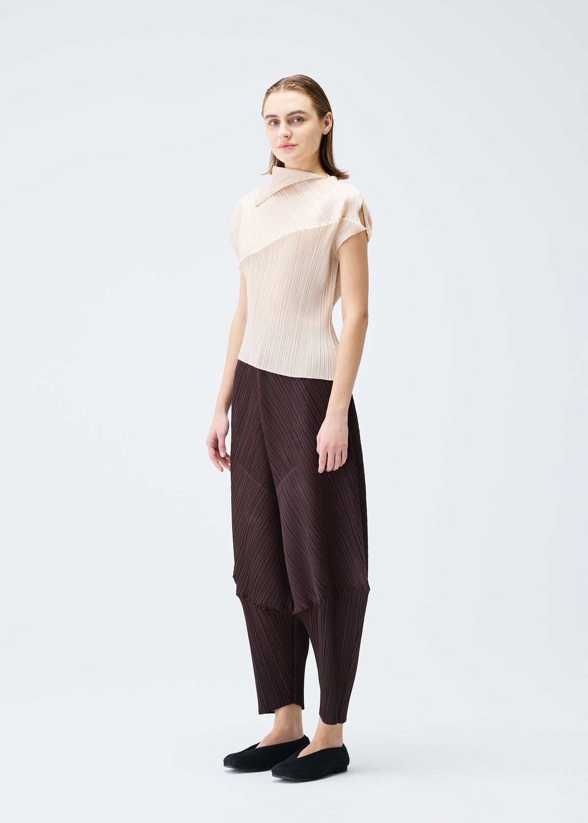 A model wears the PLEATS PLEASE ISSEY MIYAKE LEAP top.