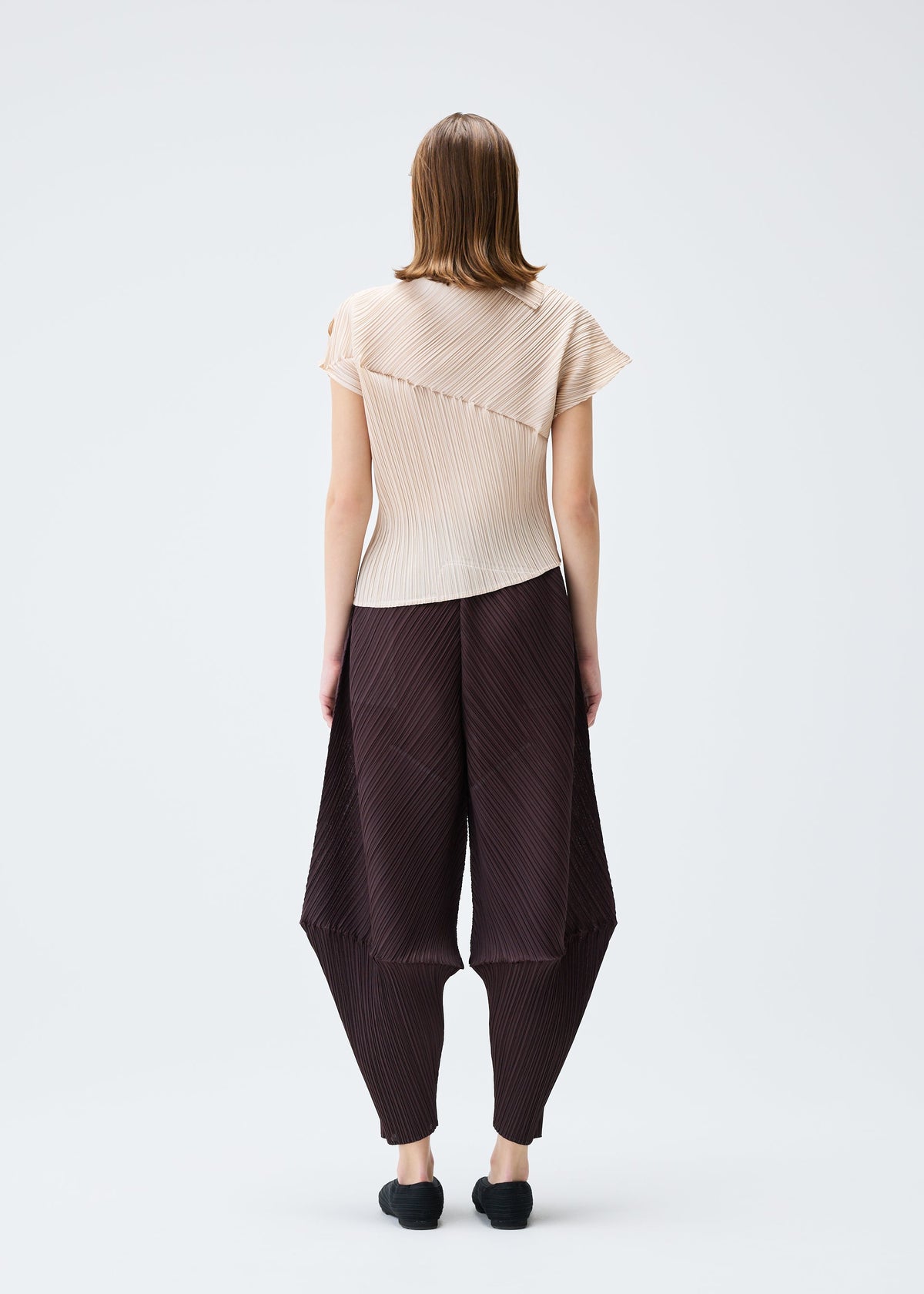 A model wears the PLEATS PLEASE ISSEY MIYAKE LEAP top.