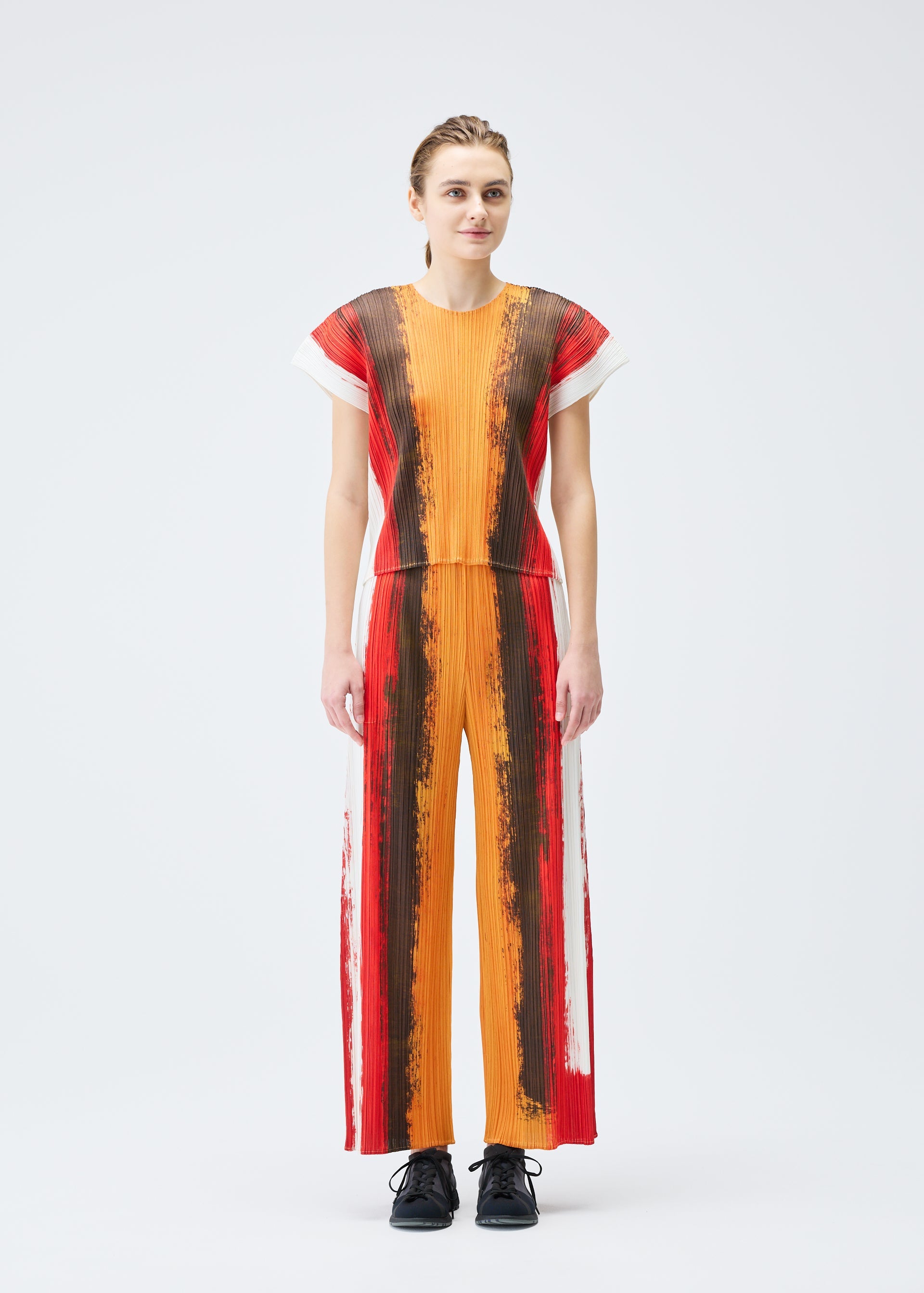 A model wears the PLEATS PLEASE ISSEY MIYAKE JUMP top.