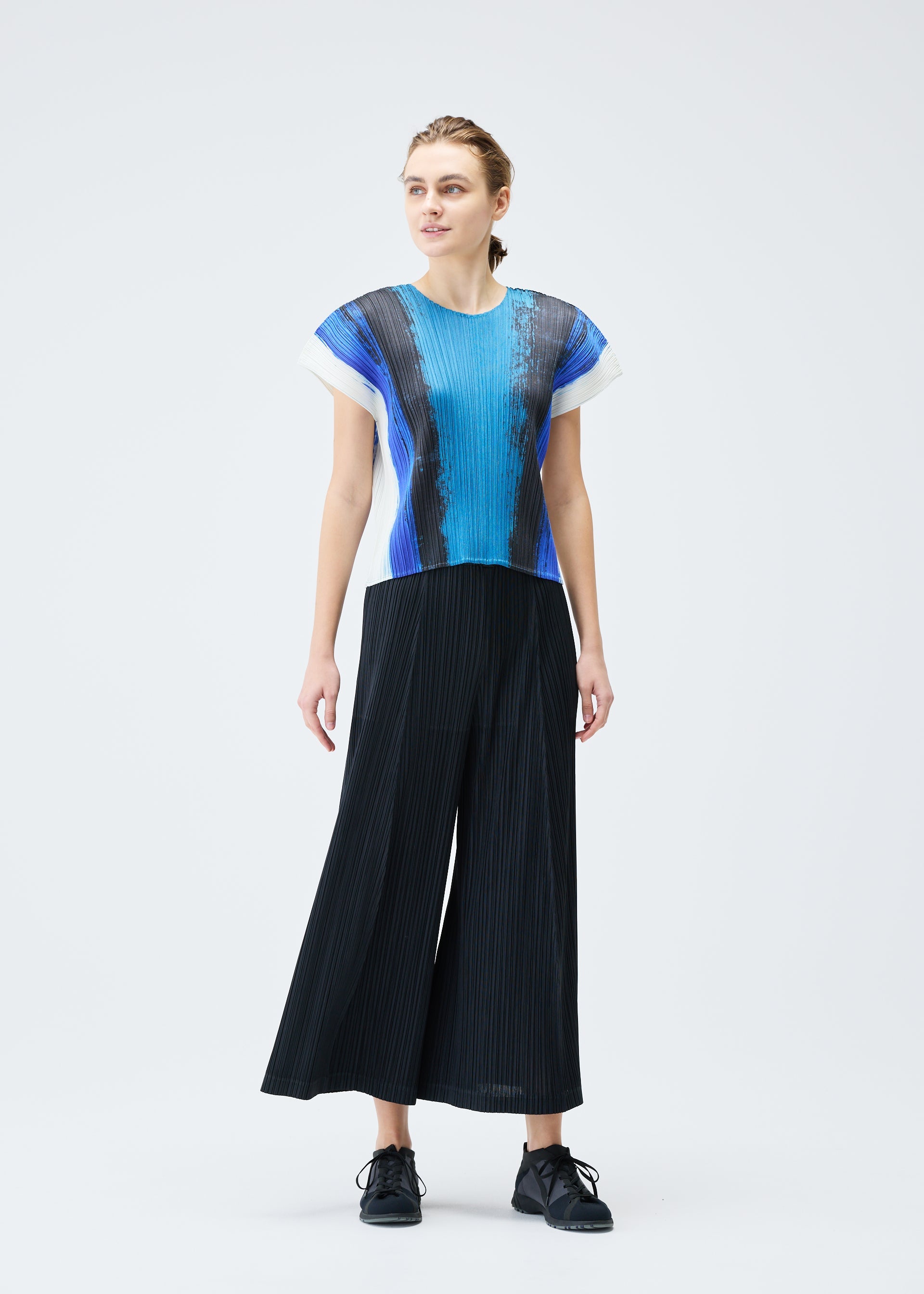 A model wears the PLEATS PLEASE ISSEY MIYAKE JUMP top.