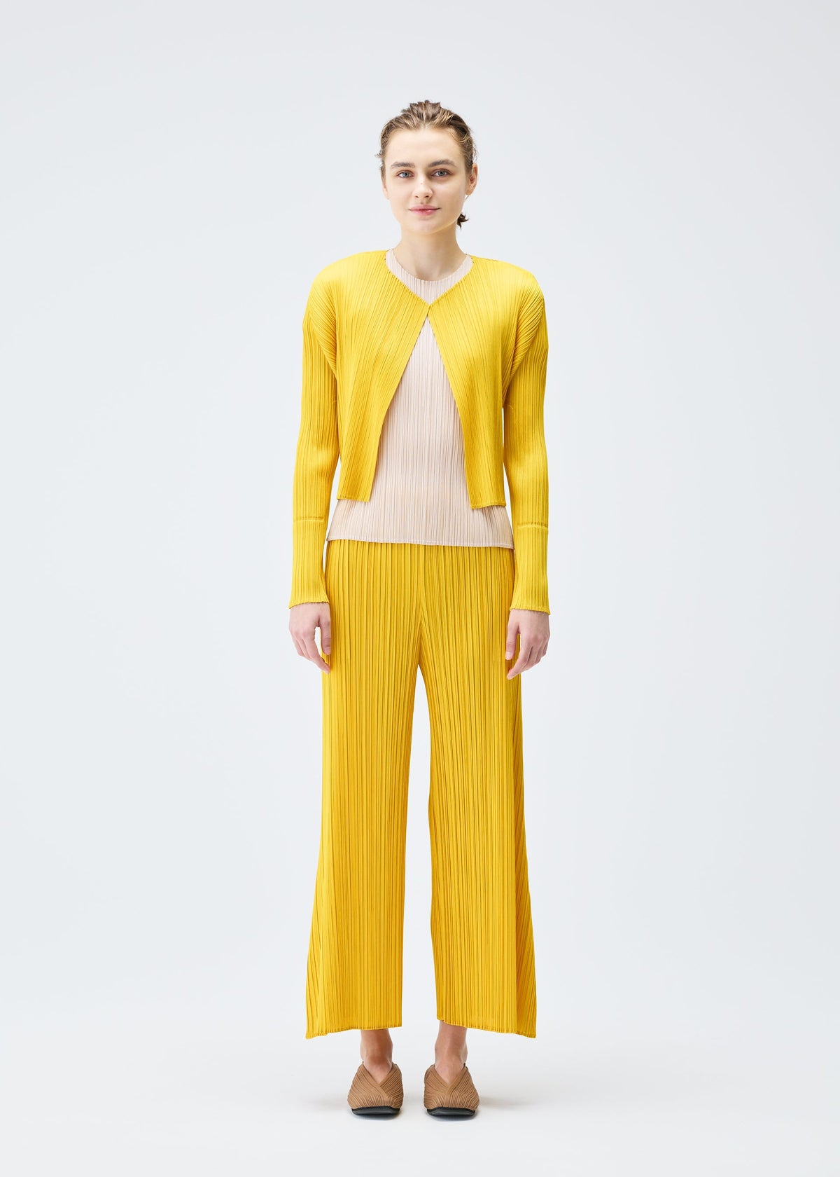 A model wears the PLEATS PLEASE ISSEY MIYAKE MONTHLY COLORS JULY cardigan.