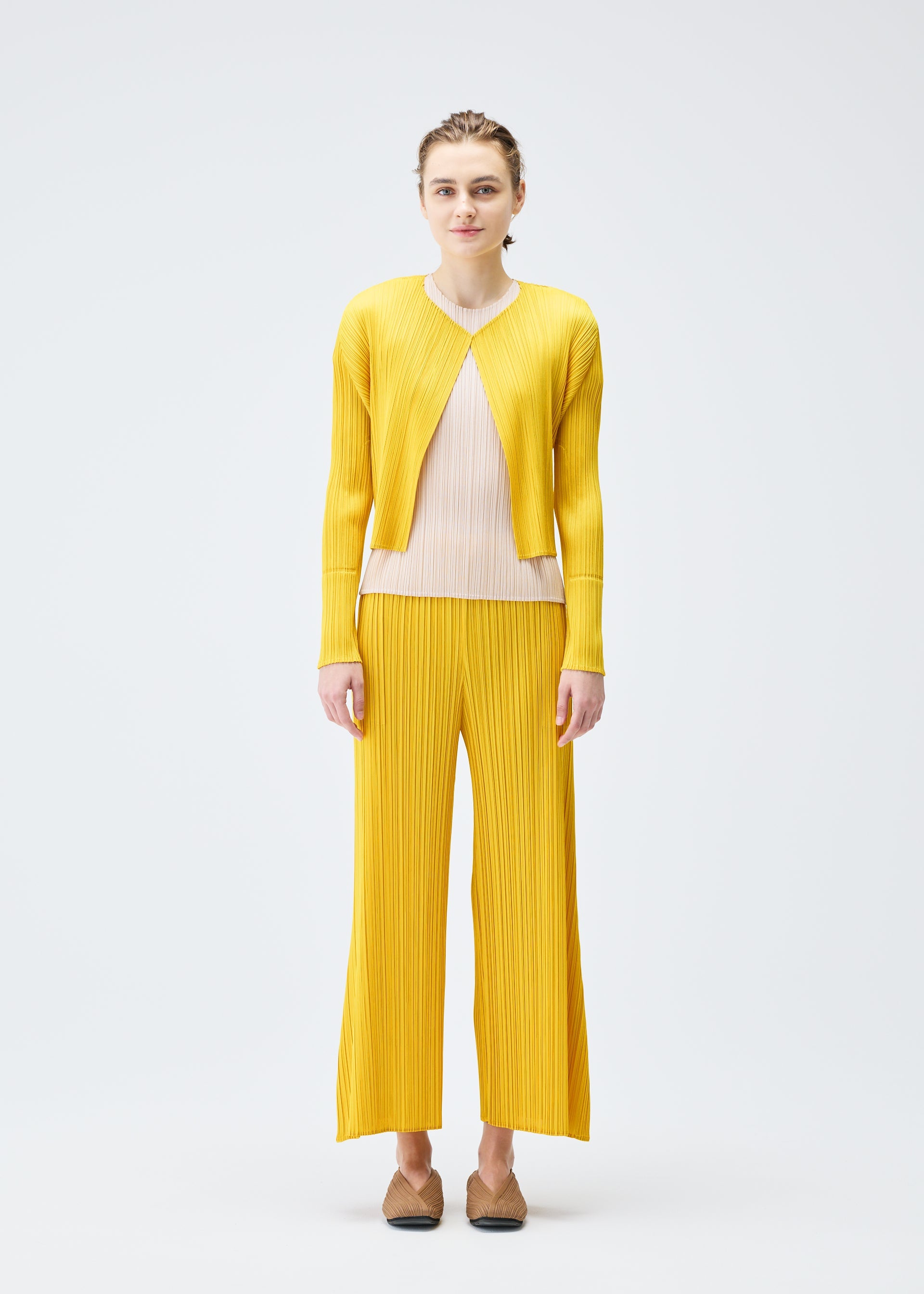 A model wears the PLEATS PLEASE ISSEY MIYAKE MONTHLY COLORS JULY cardigan.