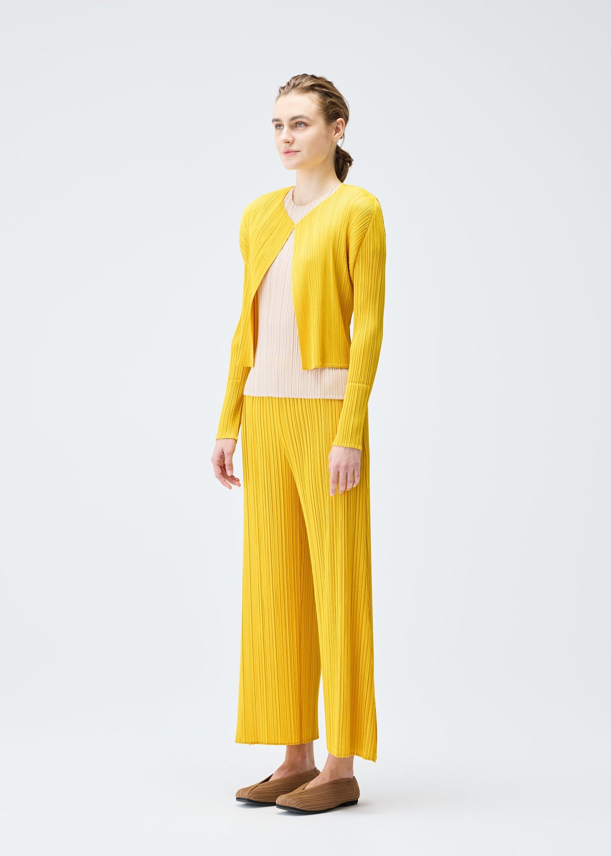 A model wears the PLEATS PLEASE ISSEY MIYAKE MONTHLY COLORS JULY cardigan.