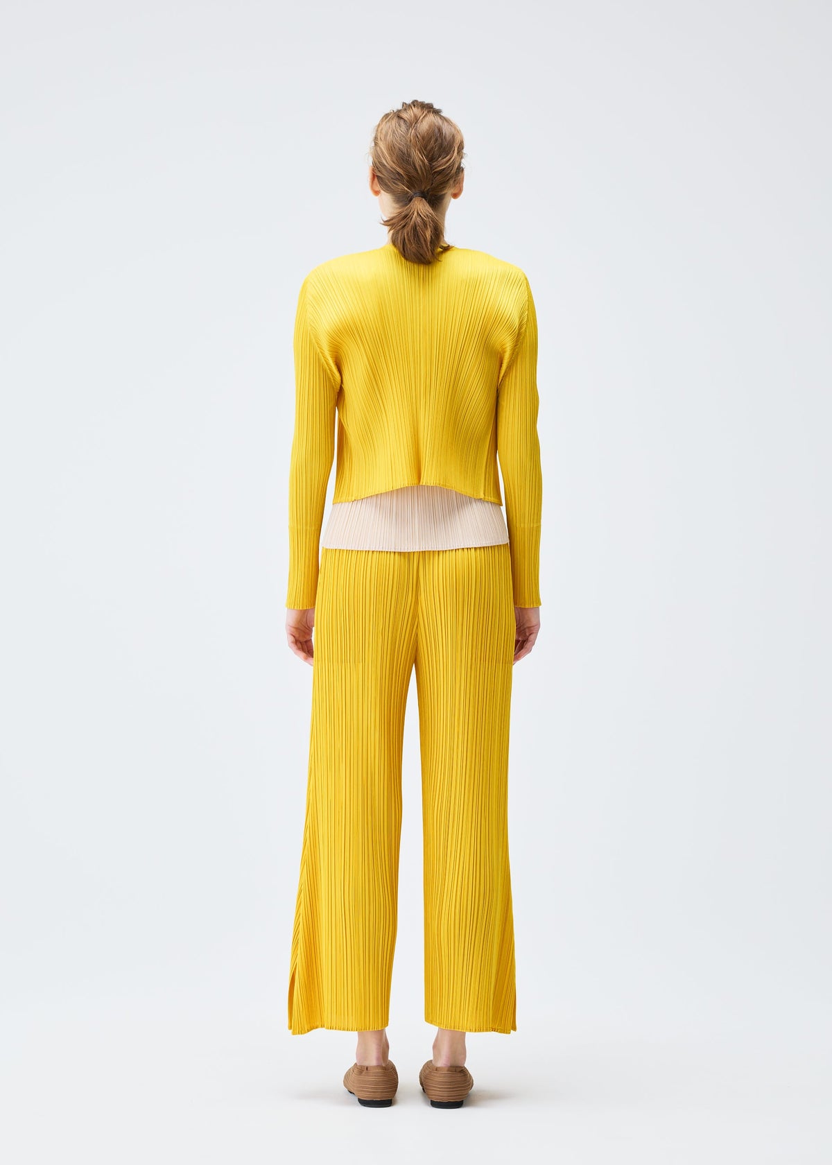 A model wears the PLEATS PLEASE ISSEY MIYAKE MONTHLY COLORS JULY cardigan.