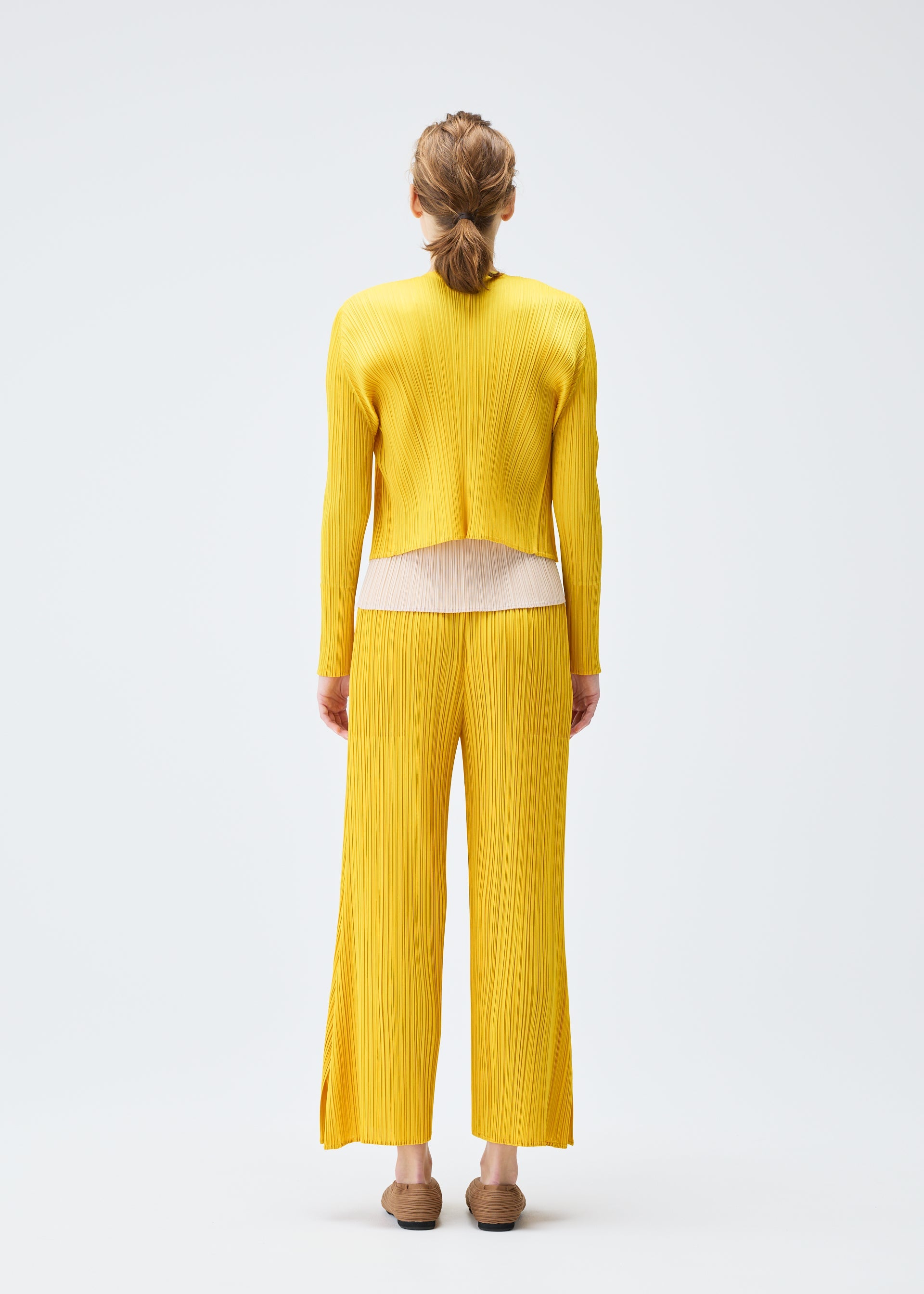 A model wears the PLEATS PLEASE ISSEY MIYAKE MONTHLY COLORS JULY cardigan.