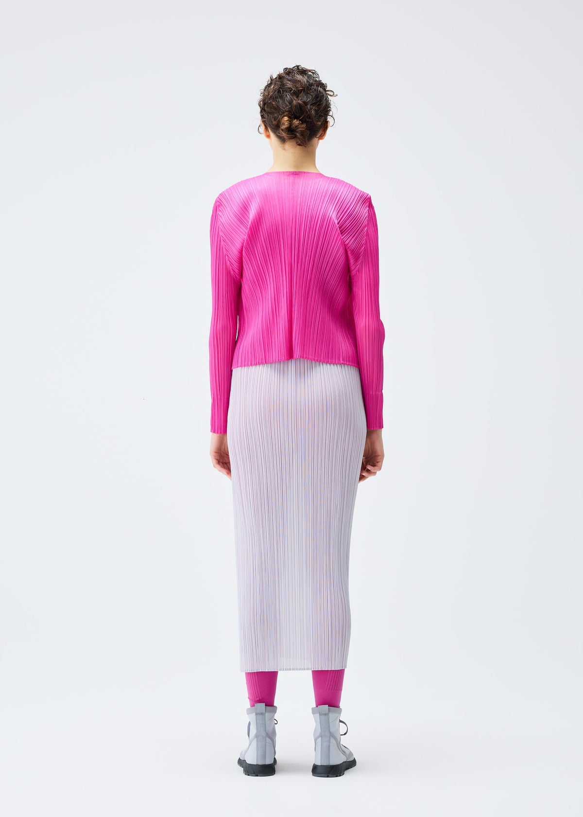 A model wears the PLEATS PLEASE ISSEY MIYAKE LUCID PLEATS cardigan.