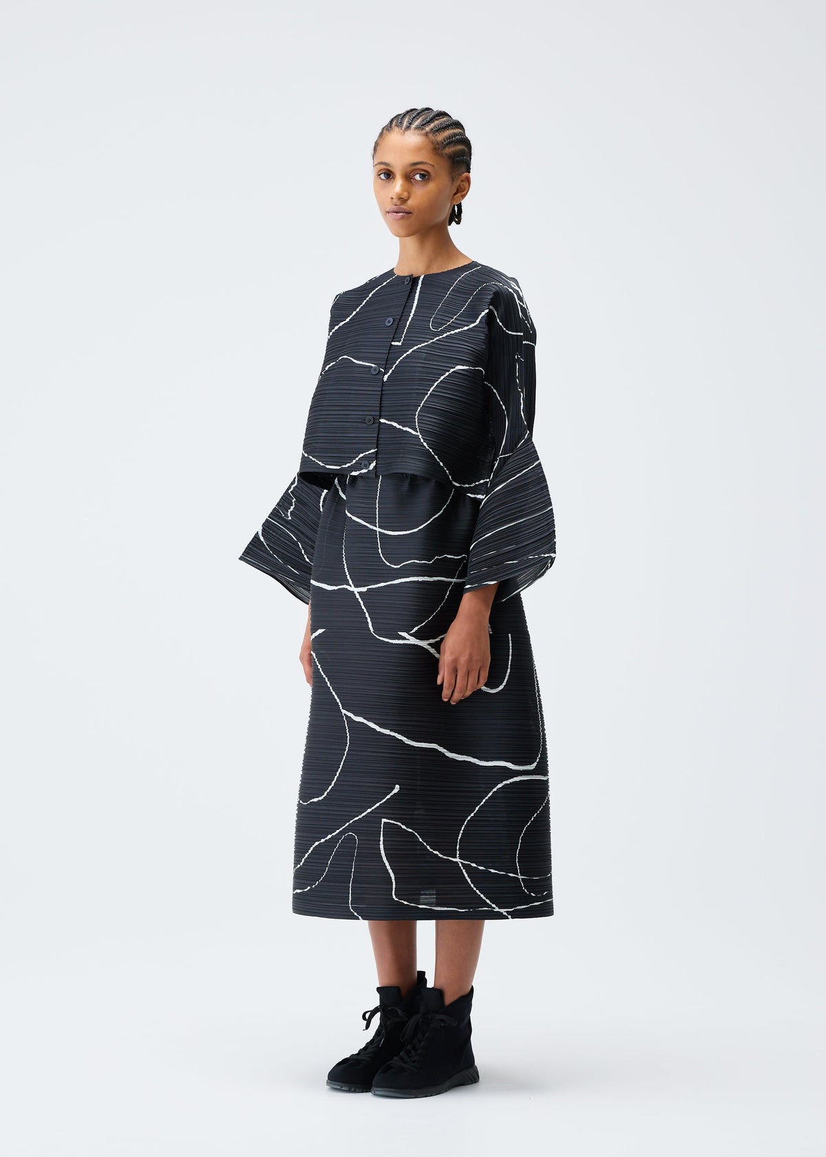 A model wears the PLEATS PLEASE ISSEY MIYAKE PAUSE cardigan.