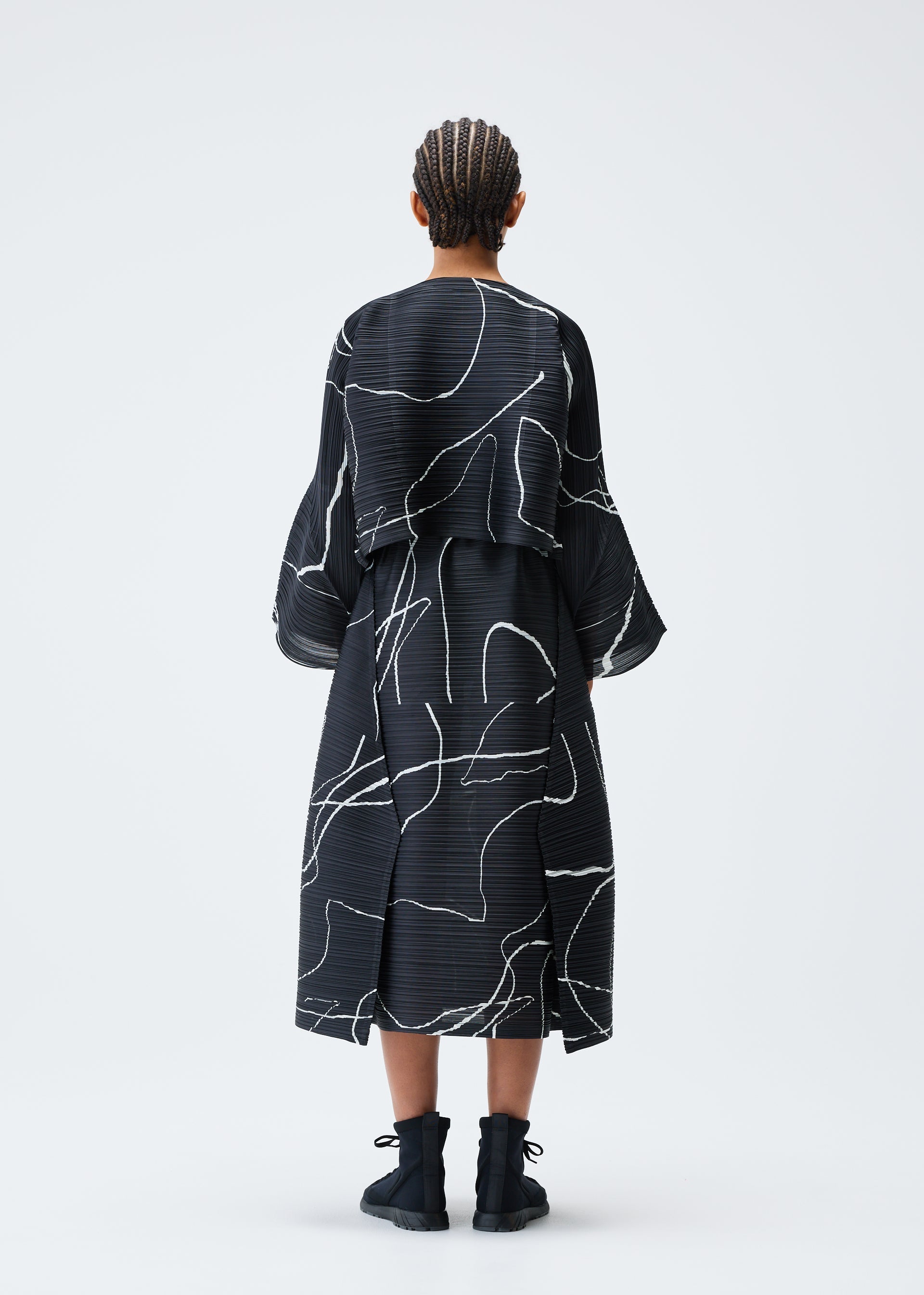 A model wears the PLEATS PLEASE ISSEY MIYAKE PAUSE cardigan.