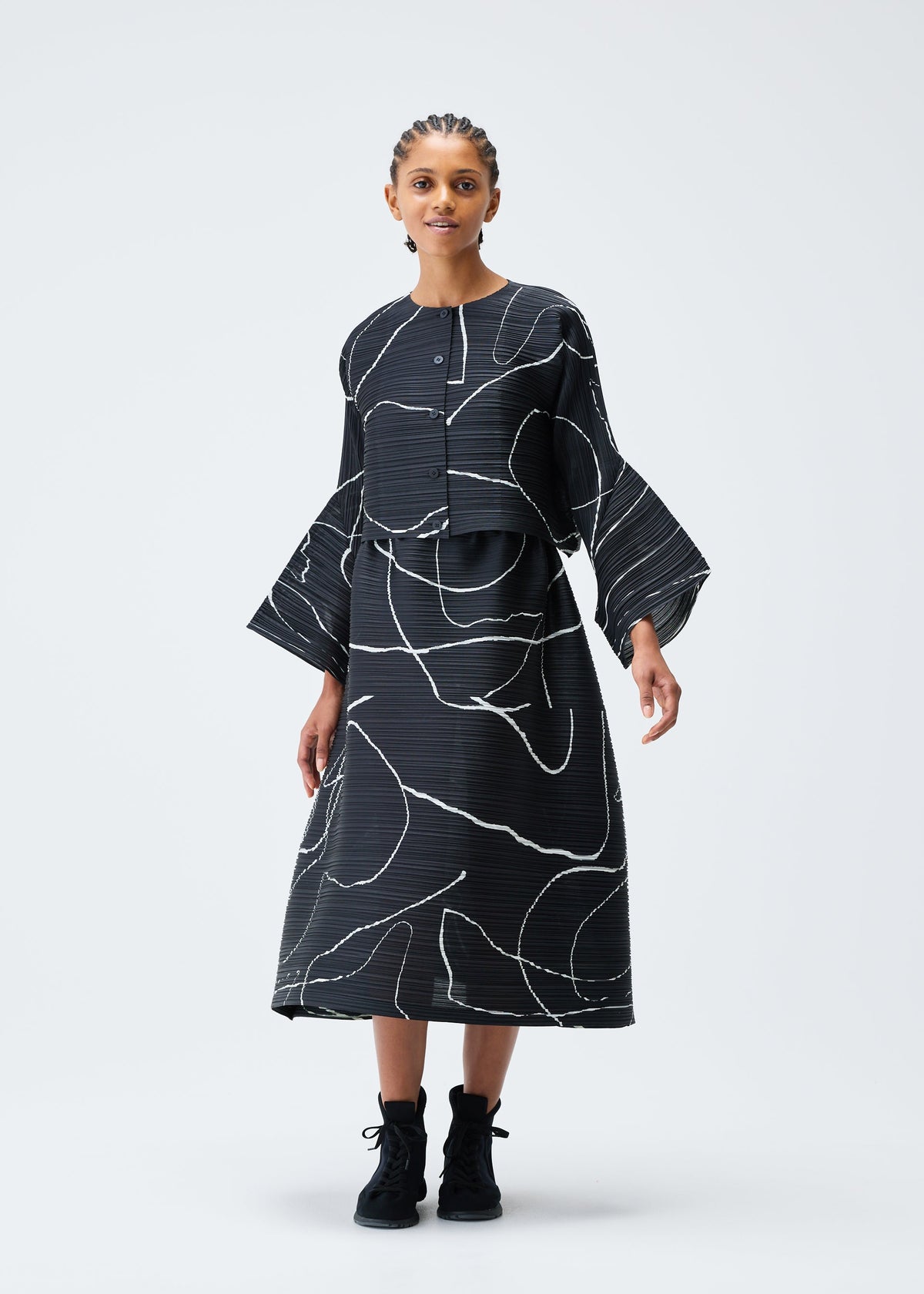 A model wears the PLEATS PLEASE ISSEY MIYAKE PAUSE cardigan.