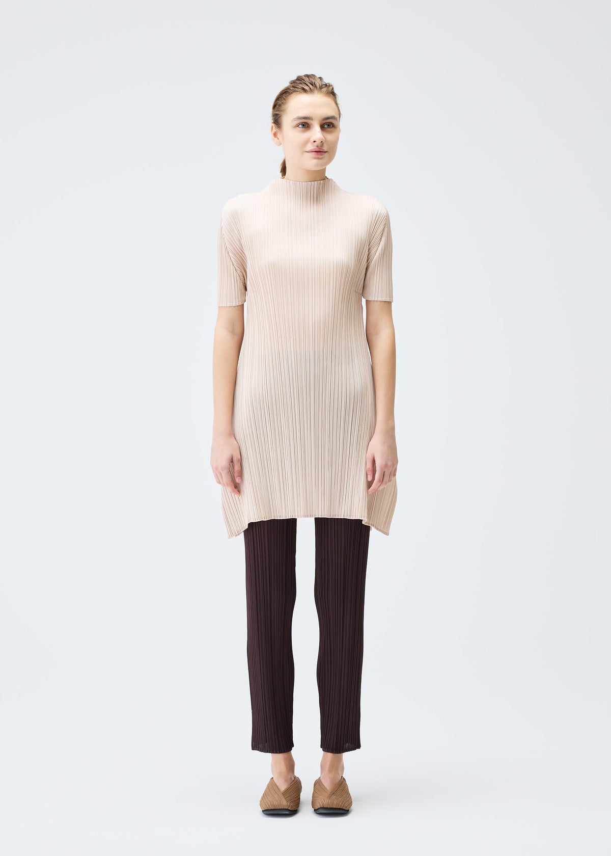 A model wears the PLEATS PLEASE ISSEY MIYAKE MONTHLY COLORS JULY tunic.