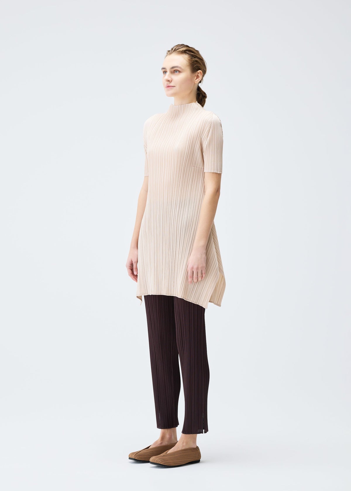 A model wears the PLEATS PLEASE ISSEY MIYAKE MONTHLY COLORS JULY tunic.