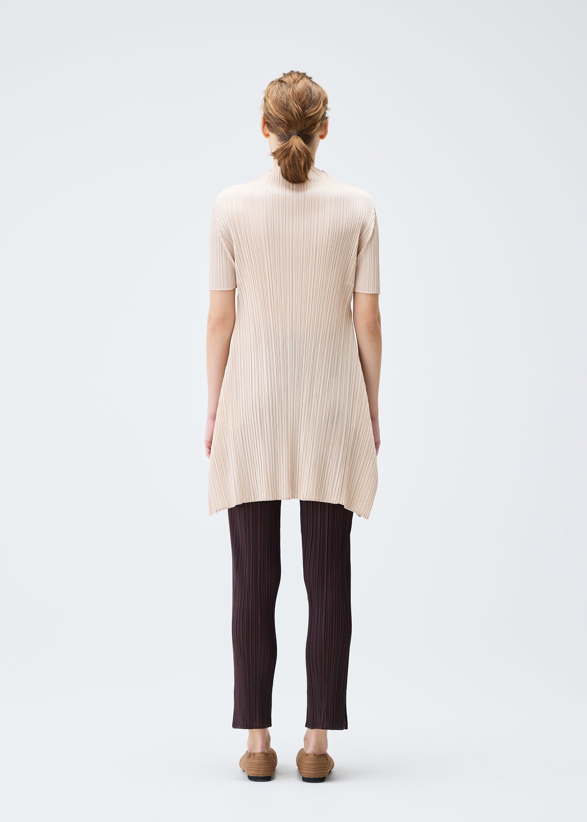 A model wears the PLEATS PLEASE ISSEY MIYAKE MONTHLY COLORS JULY tunic.