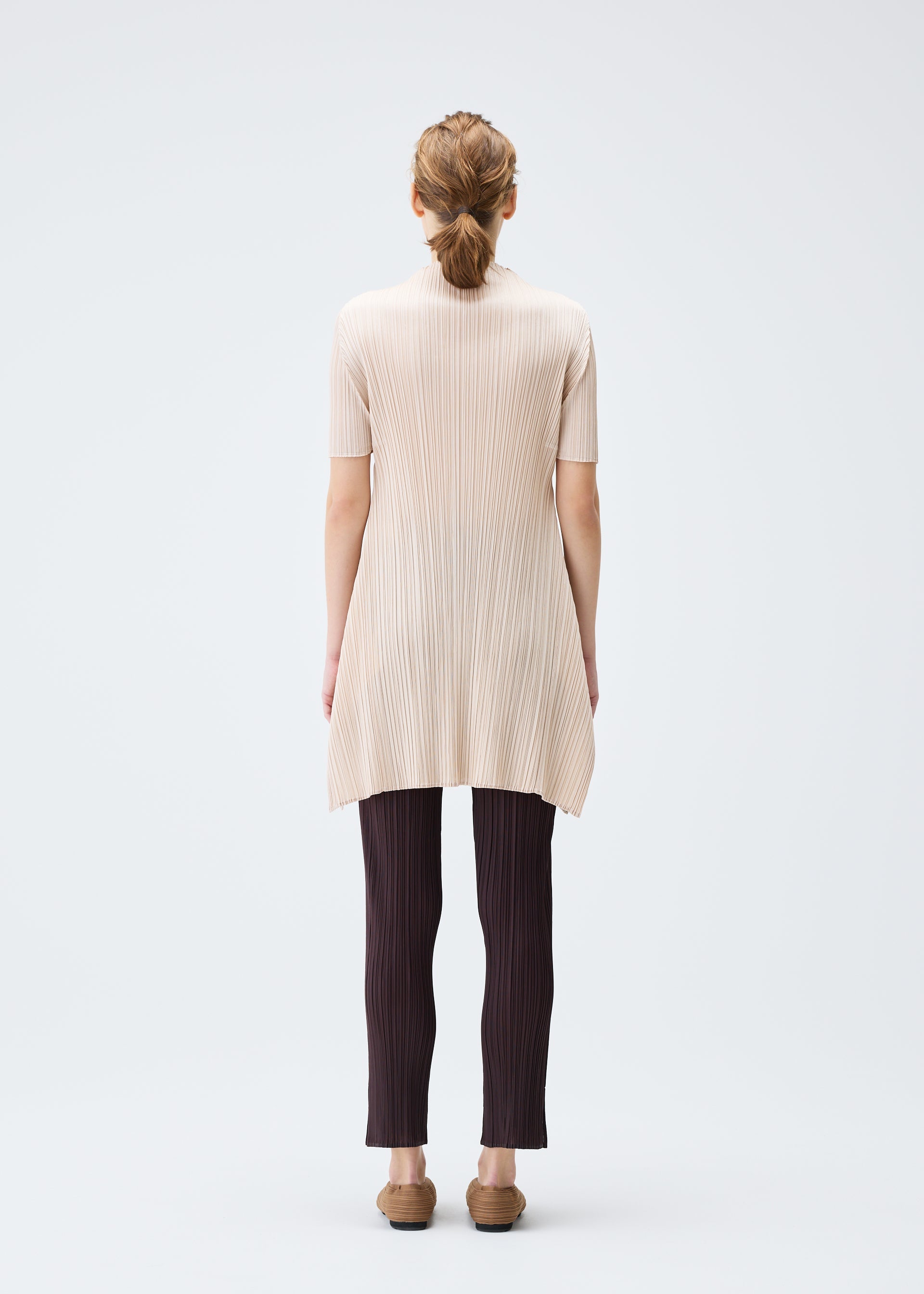 A model wears the PLEATS PLEASE ISSEY MIYAKE MONTHLY COLORS JULY tunic.