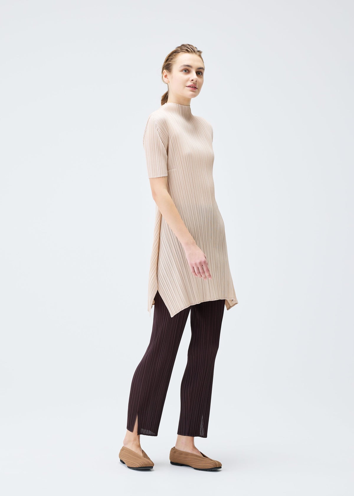 A model wears the PLEATS PLEASE ISSEY MIYAKE MONTHLY COLORS JULY tunic.