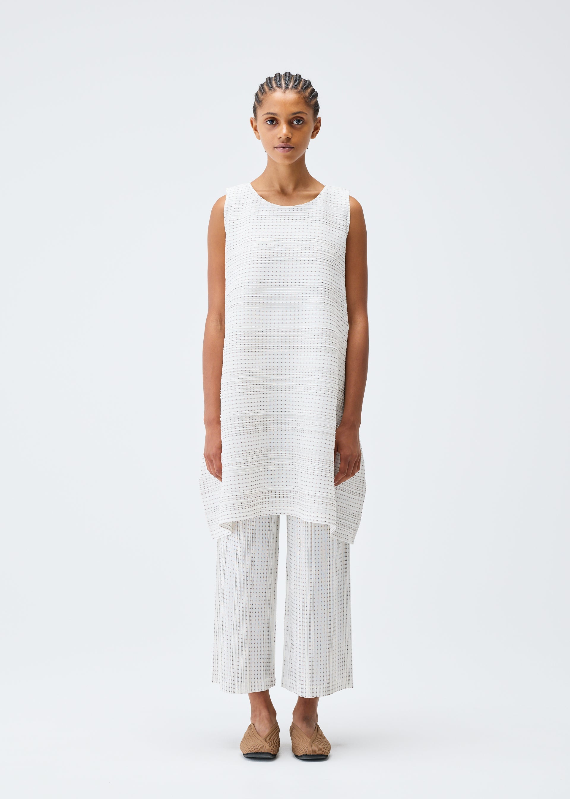 A model wears the PLEATS PLEASE ISSEY MIYAKE COTTON SKIP tunic.