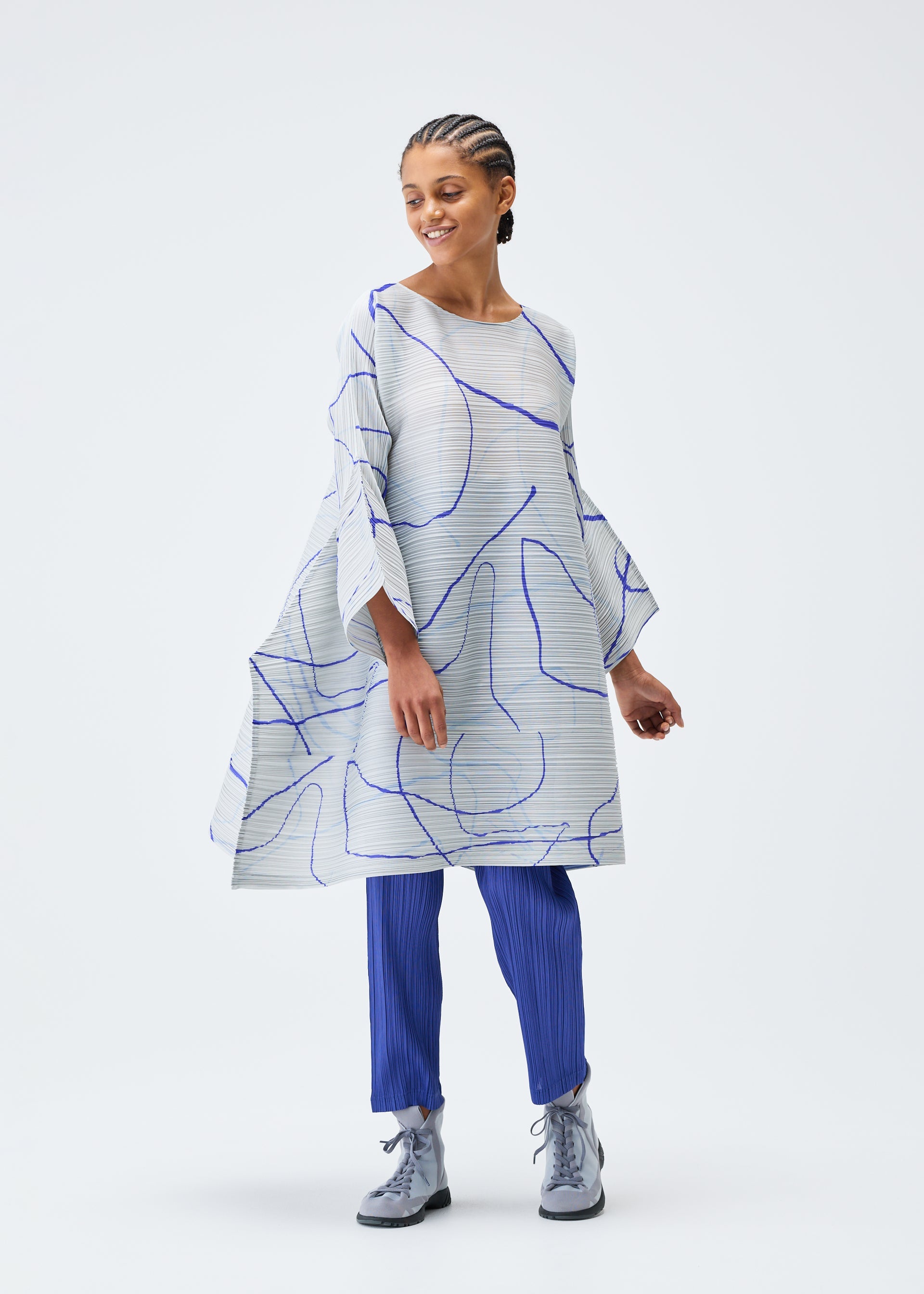 A model wears the PLEATS PLEASE ISSEY MIYAKE PAUSE tunic.