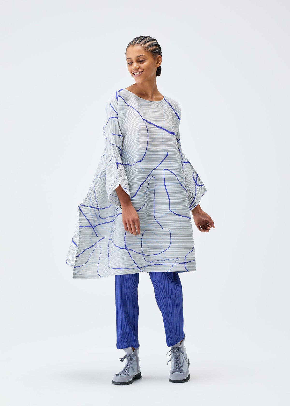 A model wears the PLEATS PLEASE ISSEY MIYAKE PAUSE tunic.