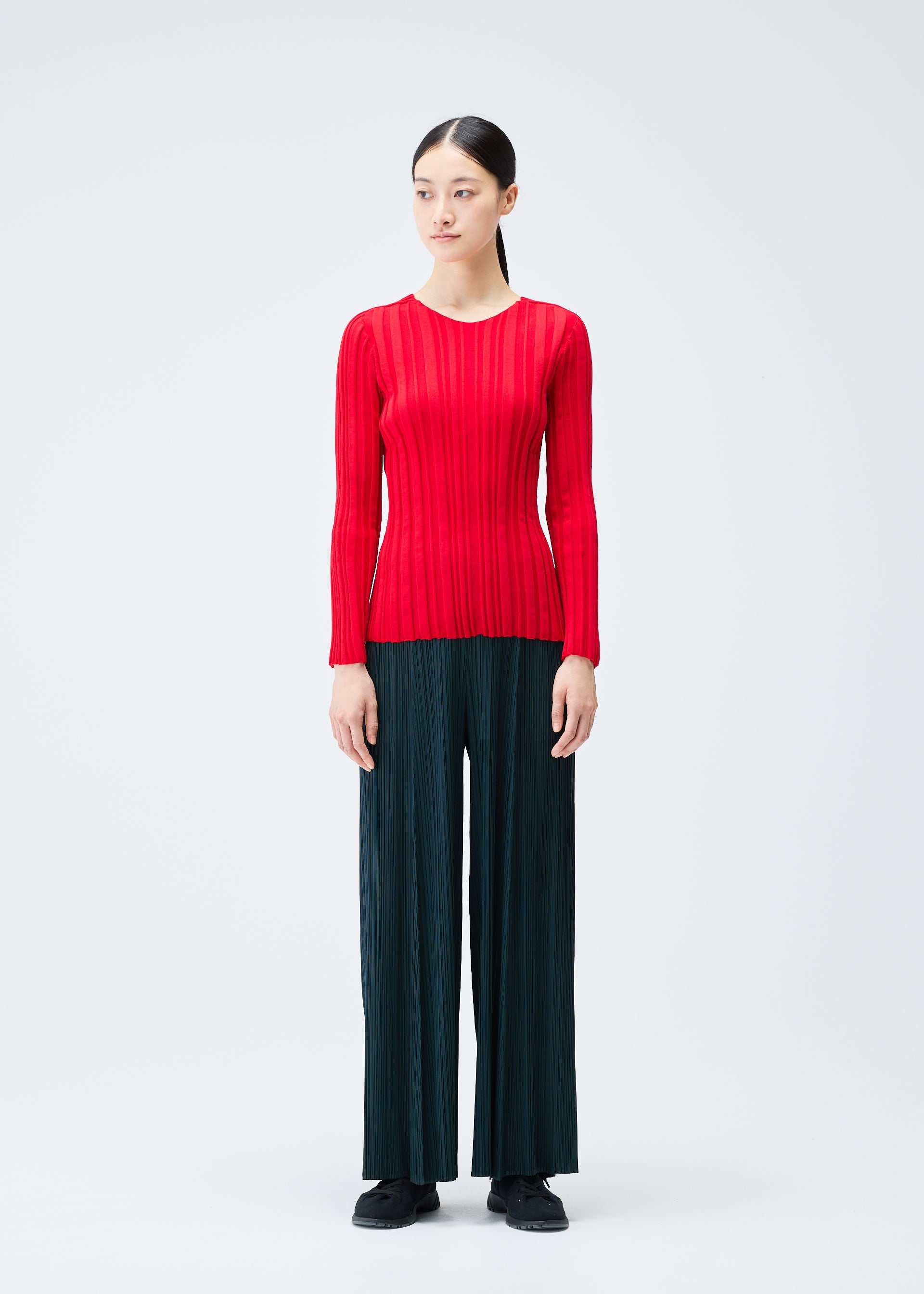 A model wears the PLEATS PLEASE ISSEY MIYAKE RIB KNIT top.