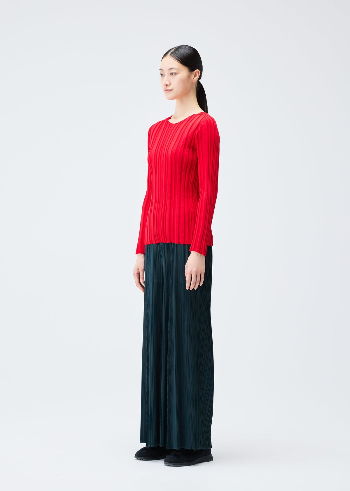 A model wears the PLEATS PLEASE ISSEY MIYAKE RIB KNIT top.