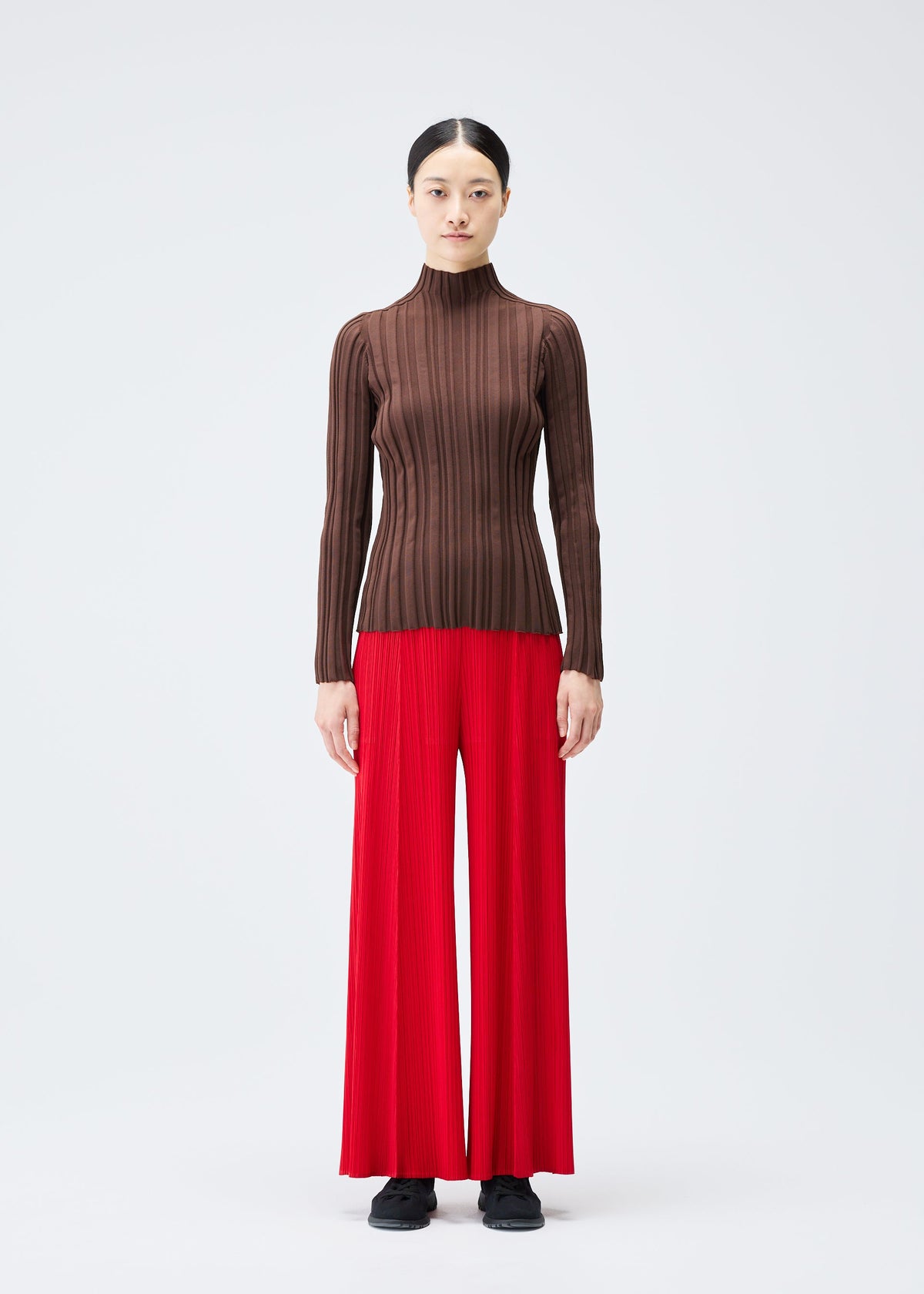 A model wears the PLEATS PLEASE ISSEY MIYAKE RIB KNIT top.