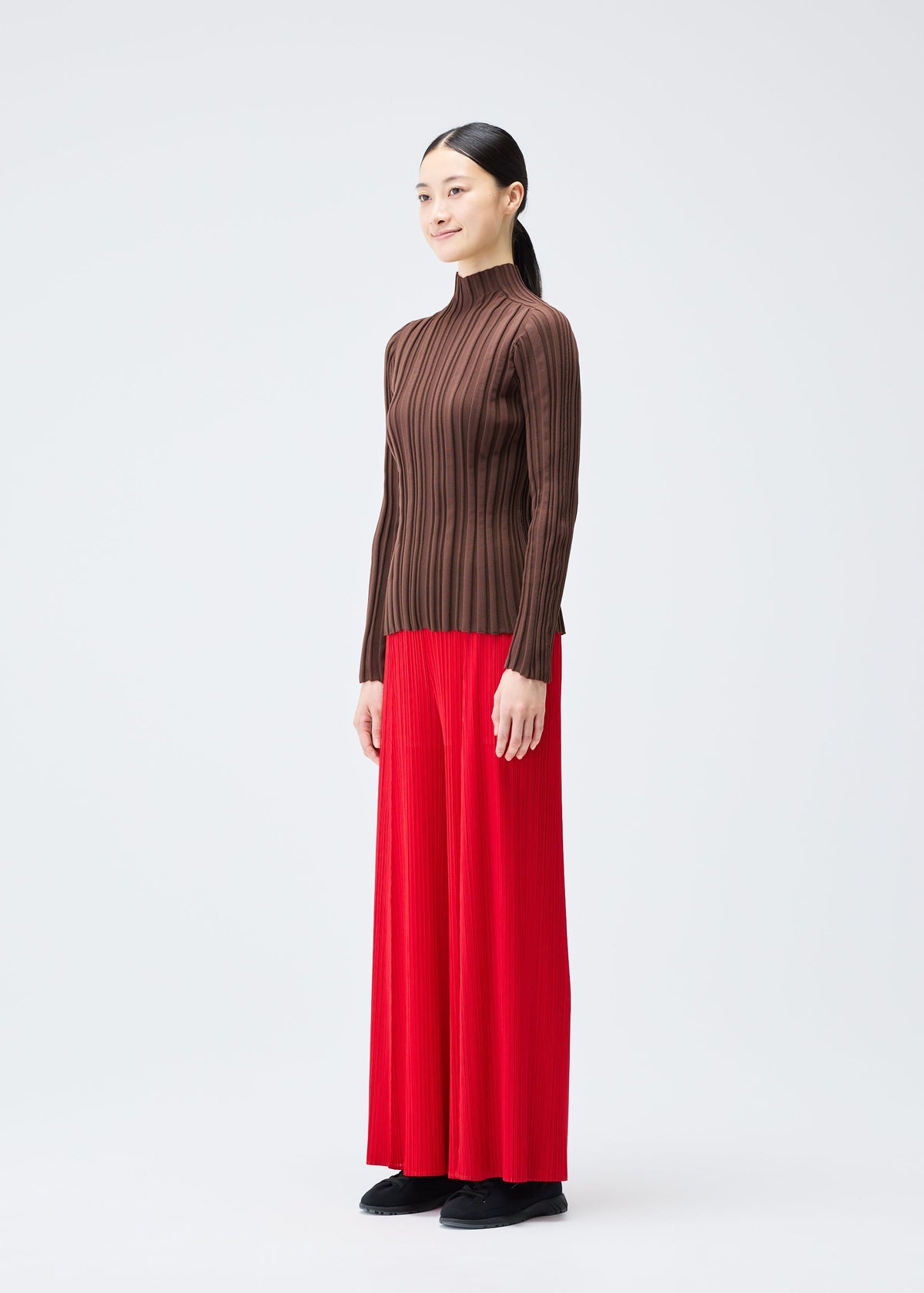 A model wears the PLEATS PLEASE ISSEY MIYAKE RIB KNIT top.