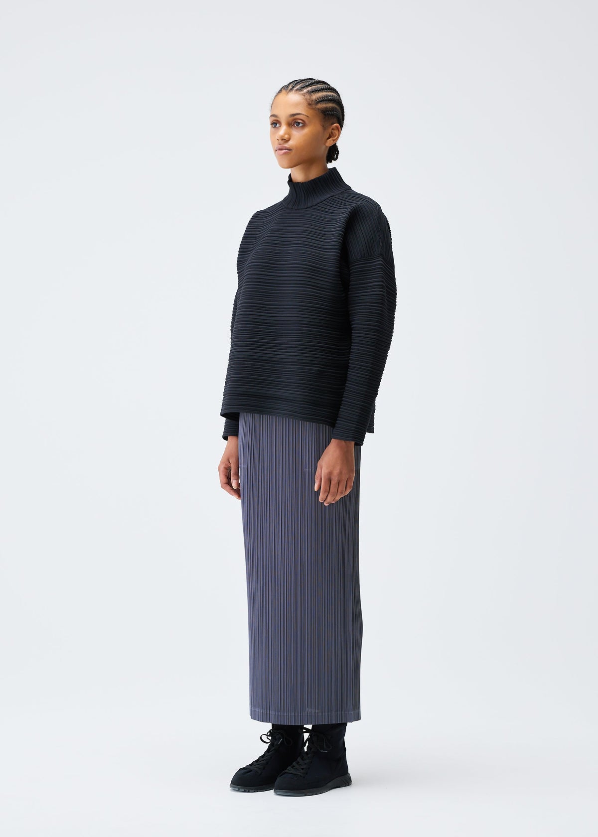 A model wears the PLEATS PLEASE ISSEY MIYAKE CREPE KNIT clothing.