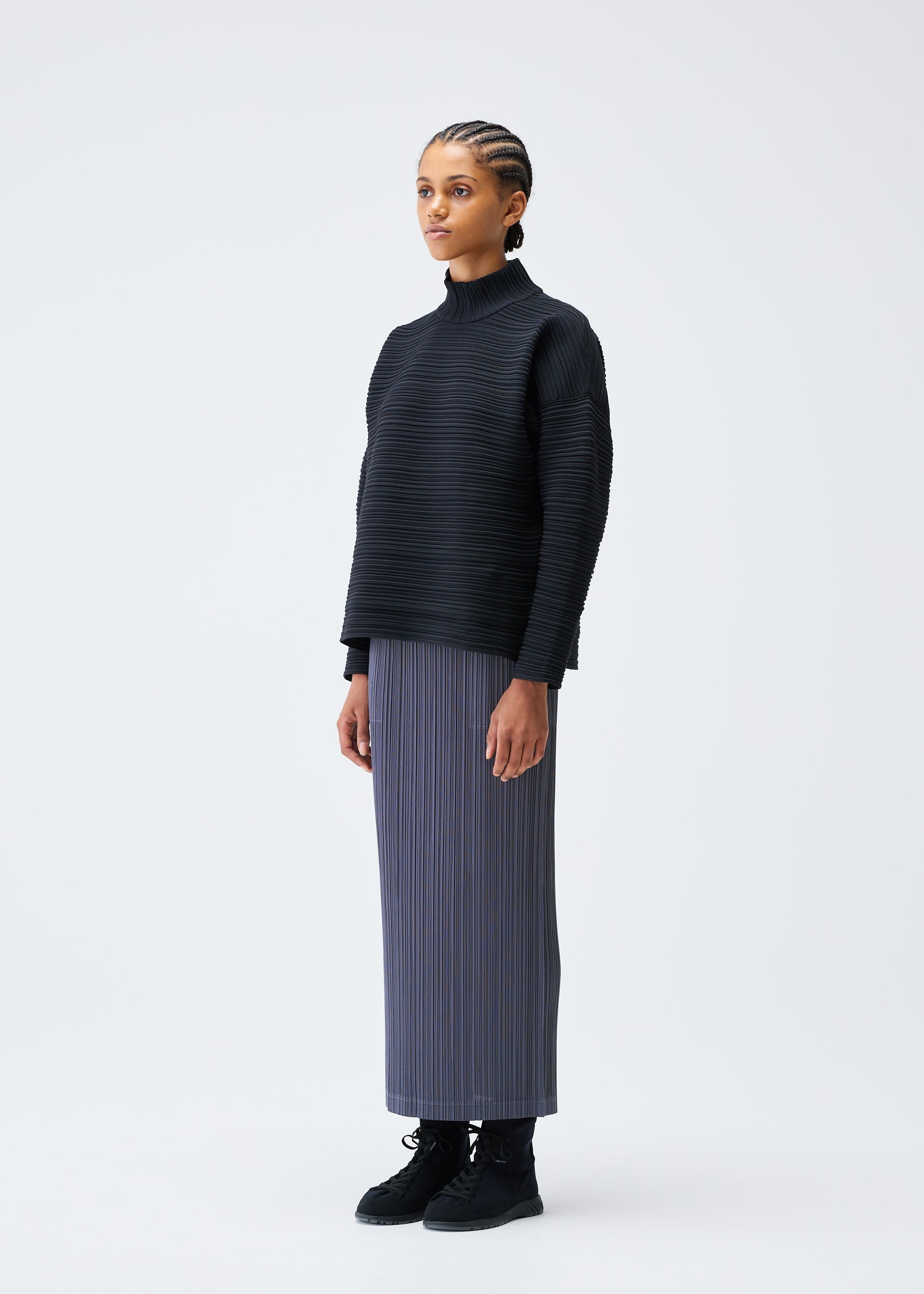 A model wears the PLEATS PLEASE ISSEY MIYAKE CREPE KNIT clothing.
