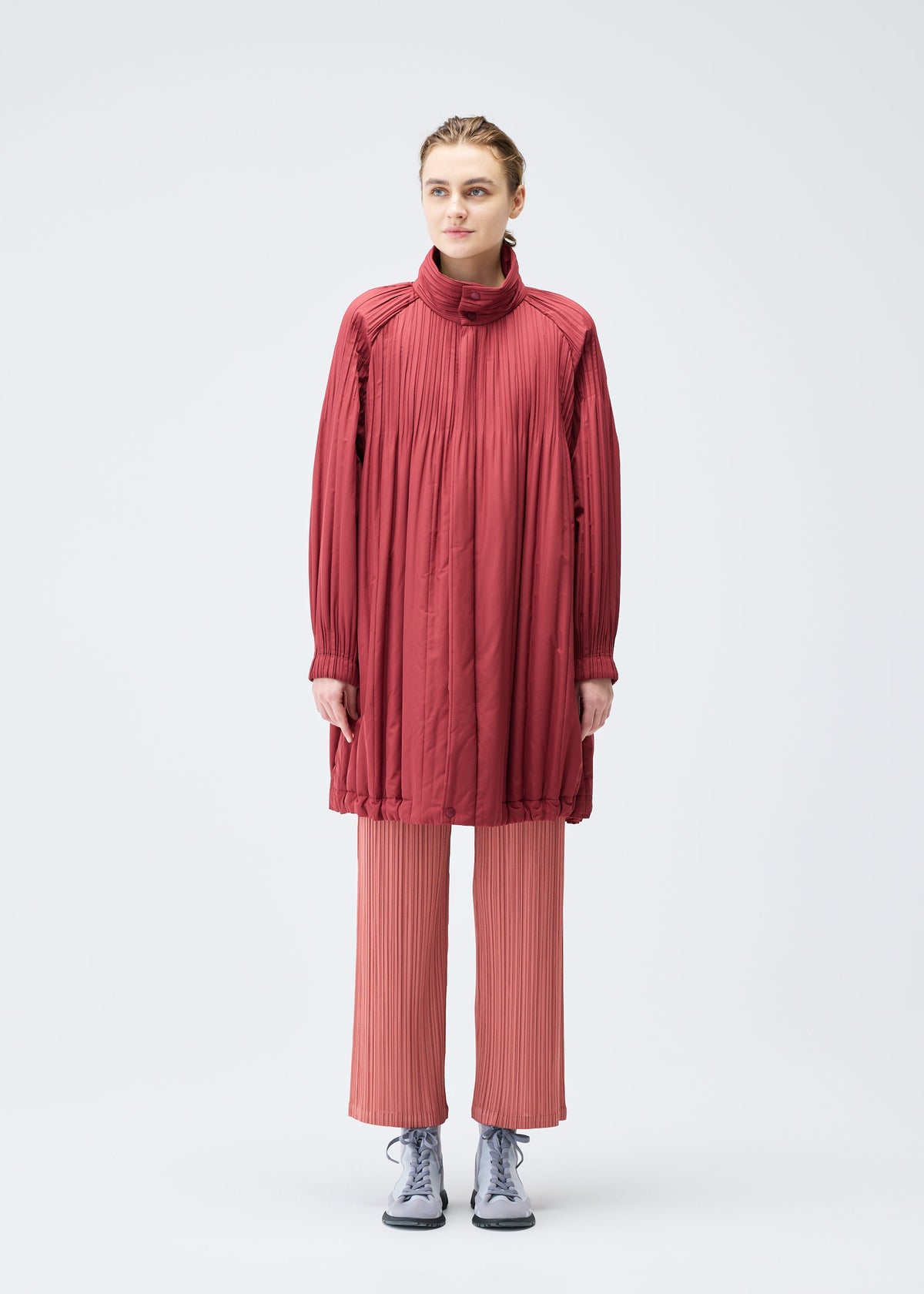 A model wears the PLEATS PLEASE ISSEY MIYAKE PADDED PLEATS COAT coat.