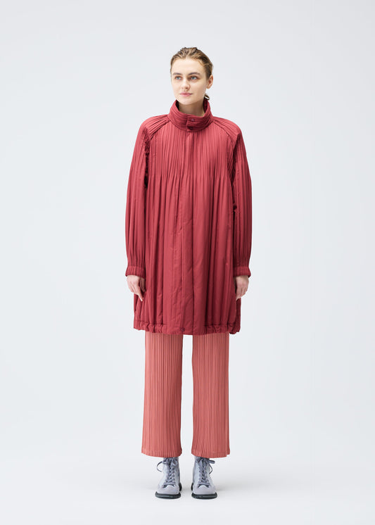 A model wears the PLEATS PLEASE ISSEY MIYAKE PADDED PLEATS COAT coat.